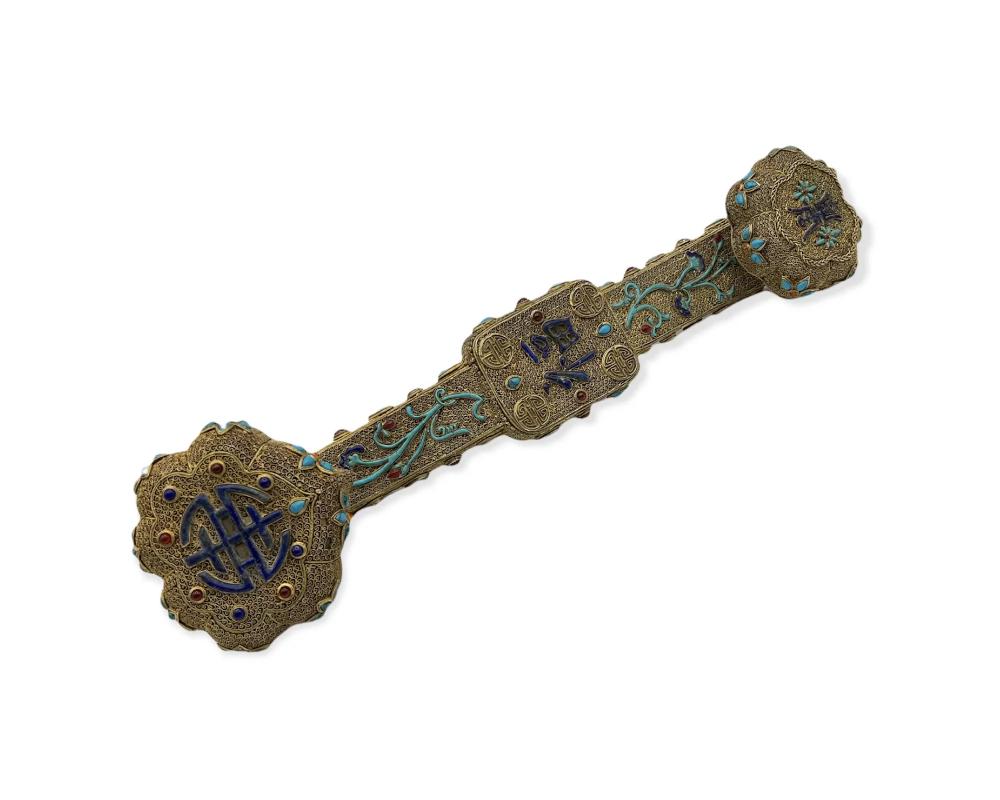 A Chinese Filigree gilt silver, jeweled, Carnelian, lapis, Turquoise, Ruyi Scepter 
Marks: four-character Qianlong nianzhi mark 
in great condition one stone is missing please see photos 
Measures: 13-1/2 x 3-1/4 x 2-5/8 inches (34.3 x 8.3 x 6.7