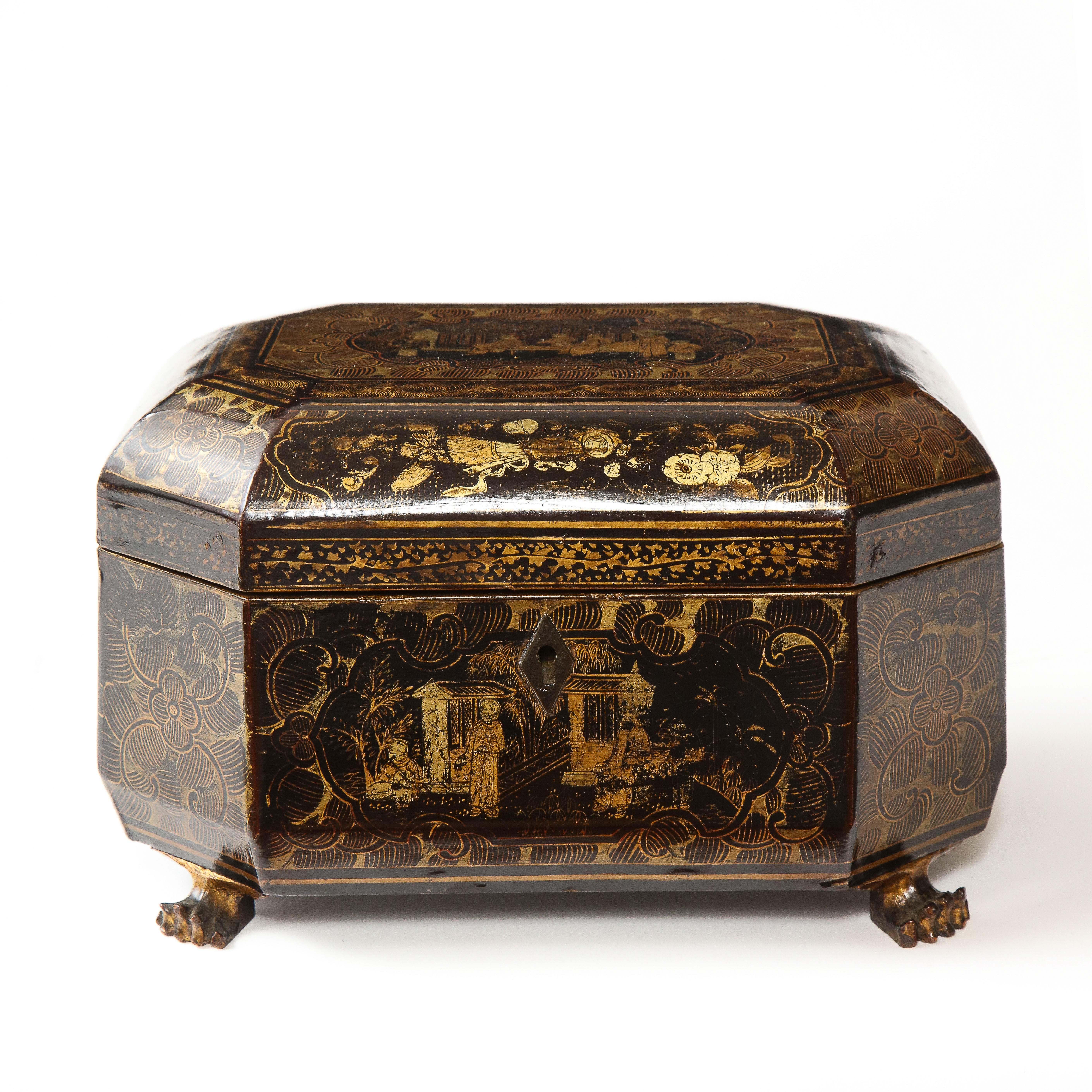 The rectangular box with canted corners, opening to a lacquered interior; decorated overall with floral and foliate motifs and cartouches of floral sprays and temples; on gilt claw feet.