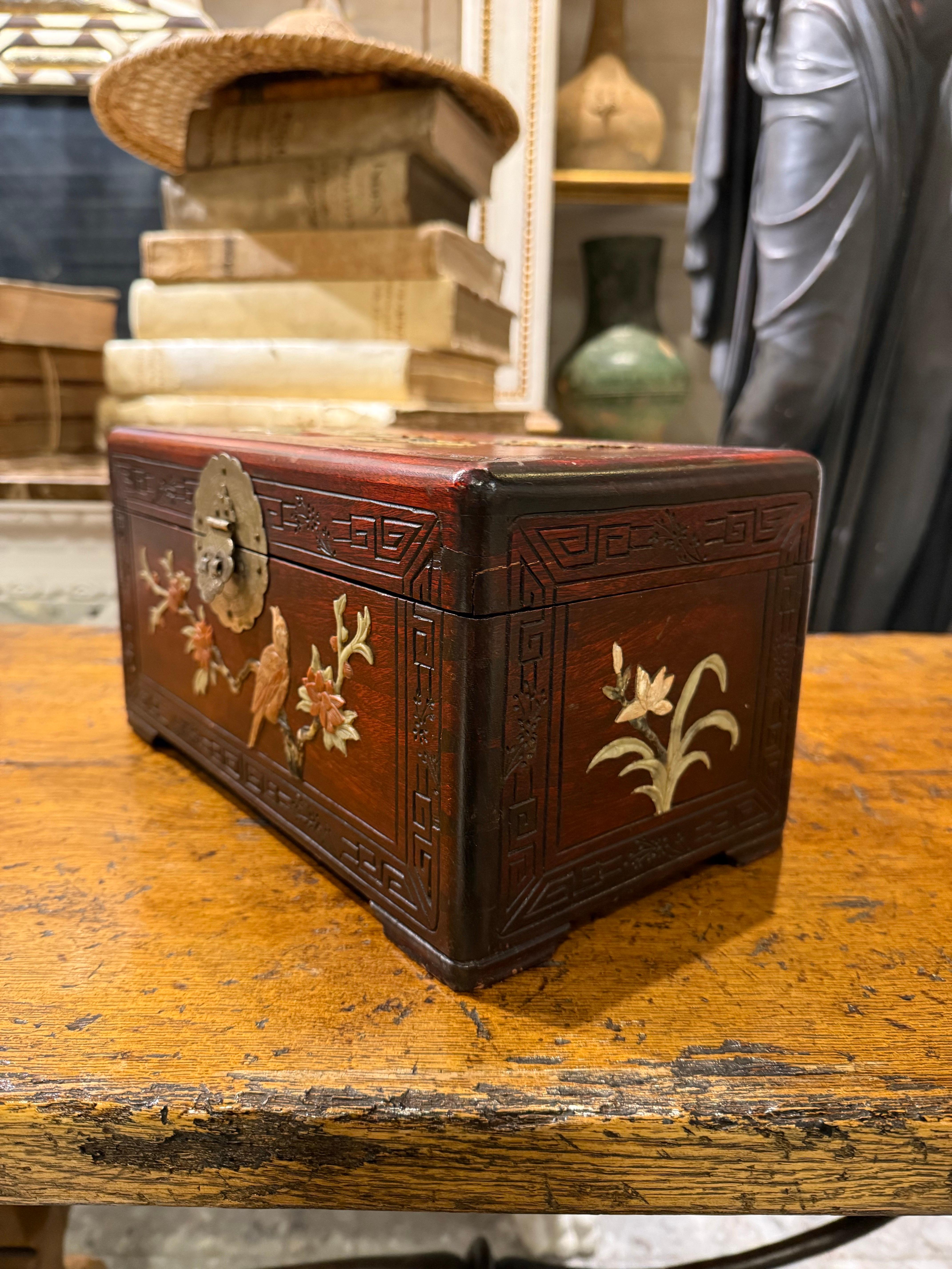Chinesische Schmuckschatulle aus geschnitztem Hartholz mit Steinintarsien, Anfang 20.

Provenienz: Private Victoria Collection'S.

Abmessungen:
Höhe: 16 cm.
Breite: 31,5 cm
Tiefe: 17,5 cm