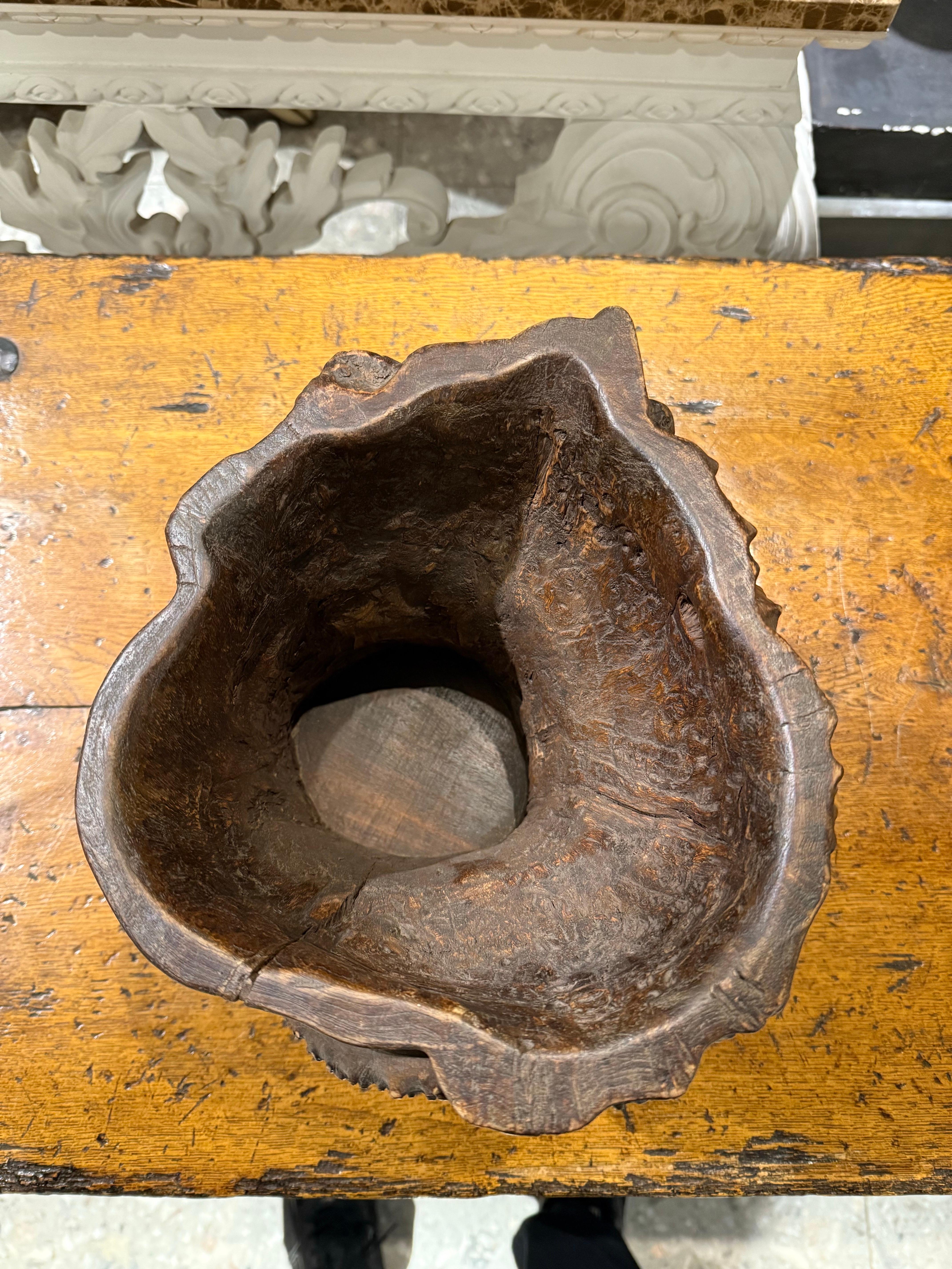 A Chinese Hardwood Gnarled Root Brush Pot, Late 19th Century

This decorative container is used to hold writing brushes and popular during the Qing dynasty (1644–1911). It was revered for its organic, wild appearance, evoking the image of an