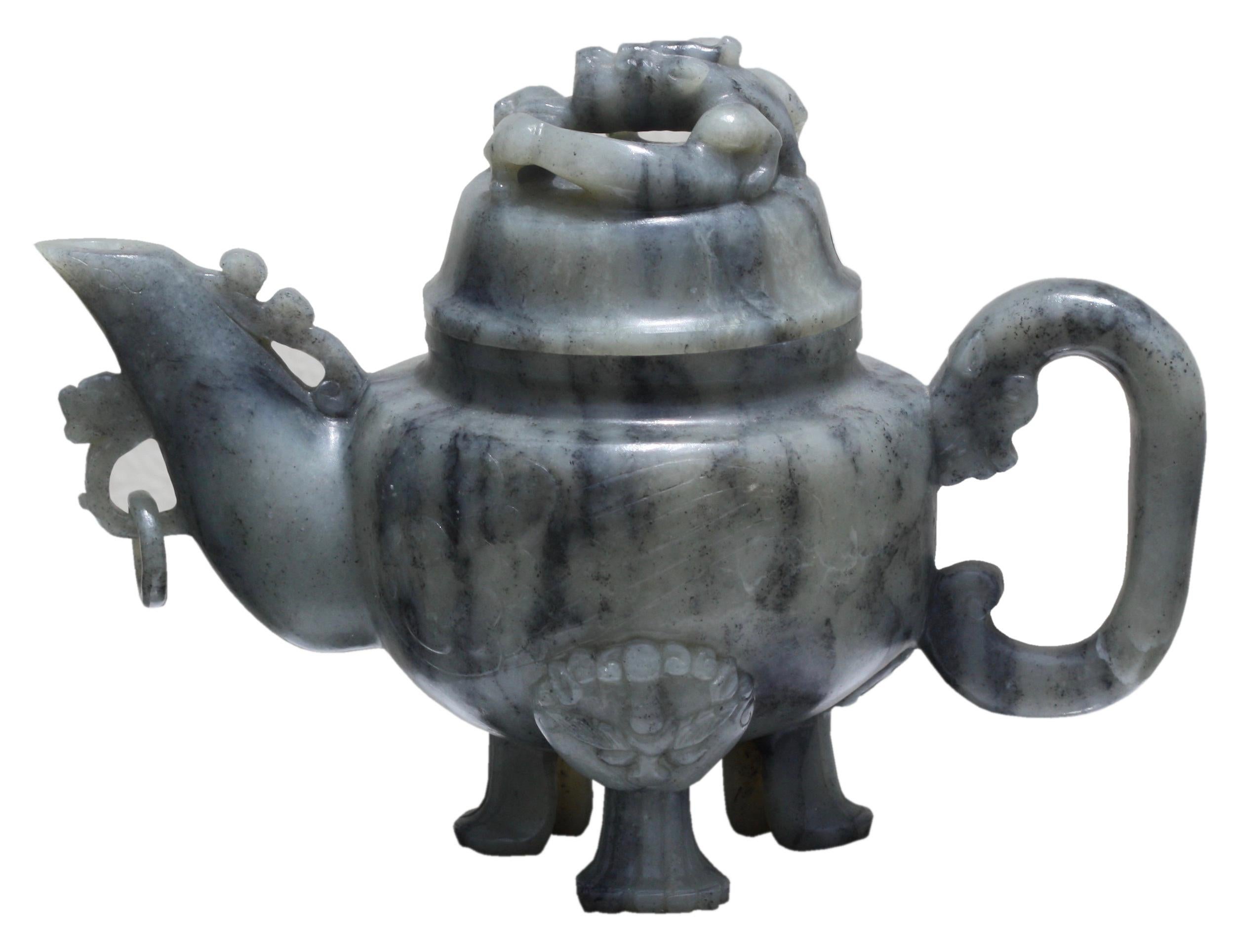 Eine chinesische Jade-Teekanne mit Deckel 
von grauer und schwarzer Farbe, die Oberfläche hochglanzpoliert und in sehr flachem Relief auf der einen Seite mit einem Pflaumenbaum und Felsen und auf der anderen Seite mit einem Felsen beschnitzt, mit