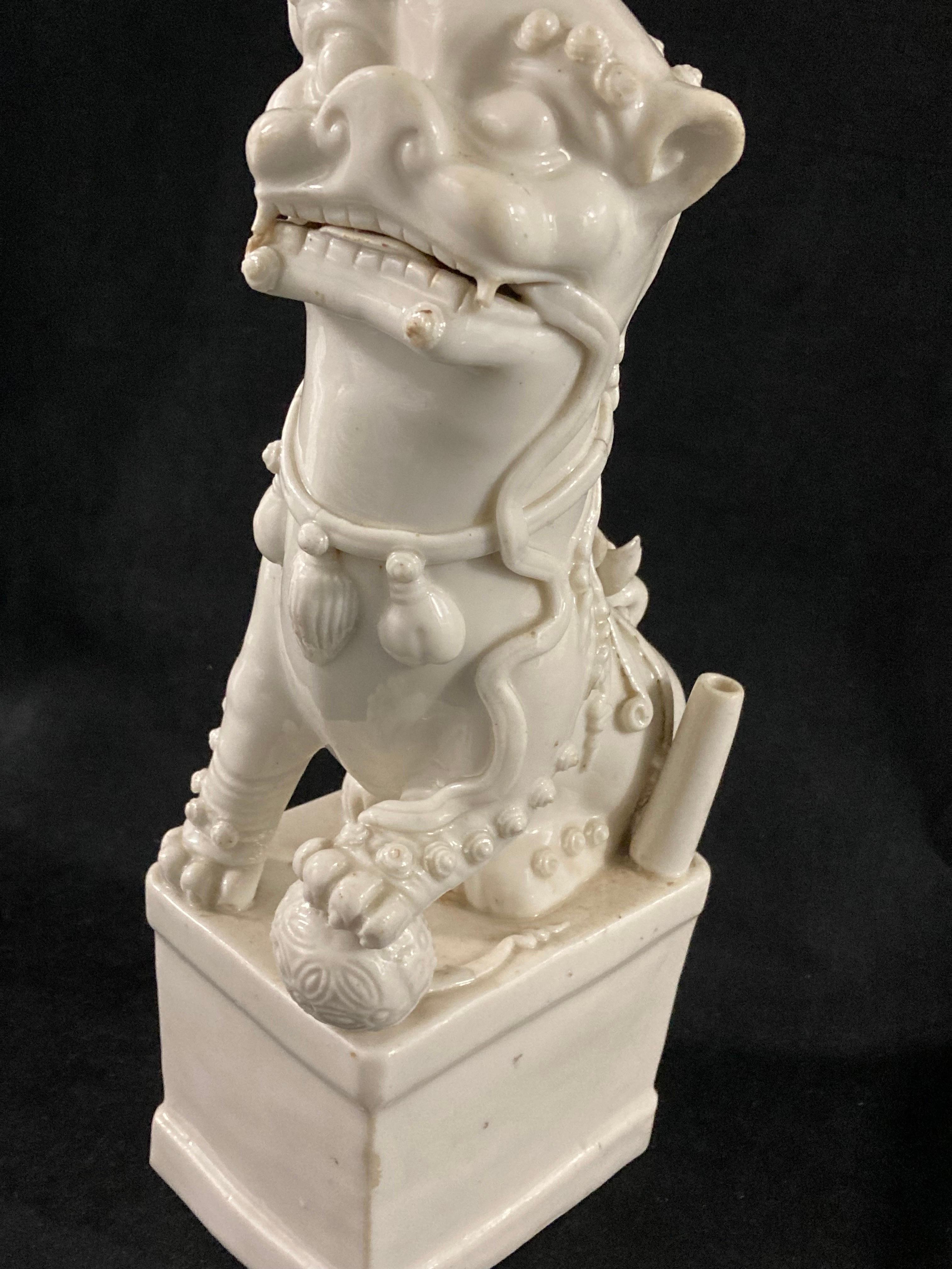 Perro Foo de porcelana china del periodo Kangxi, hacia 1680.

Muy bien modelado para mostrar al perro macho colocando la pata sobre una pelota de brocado. 
Blanc de chine era el término que se daba en Occidente a la porcelana blanca, pero se