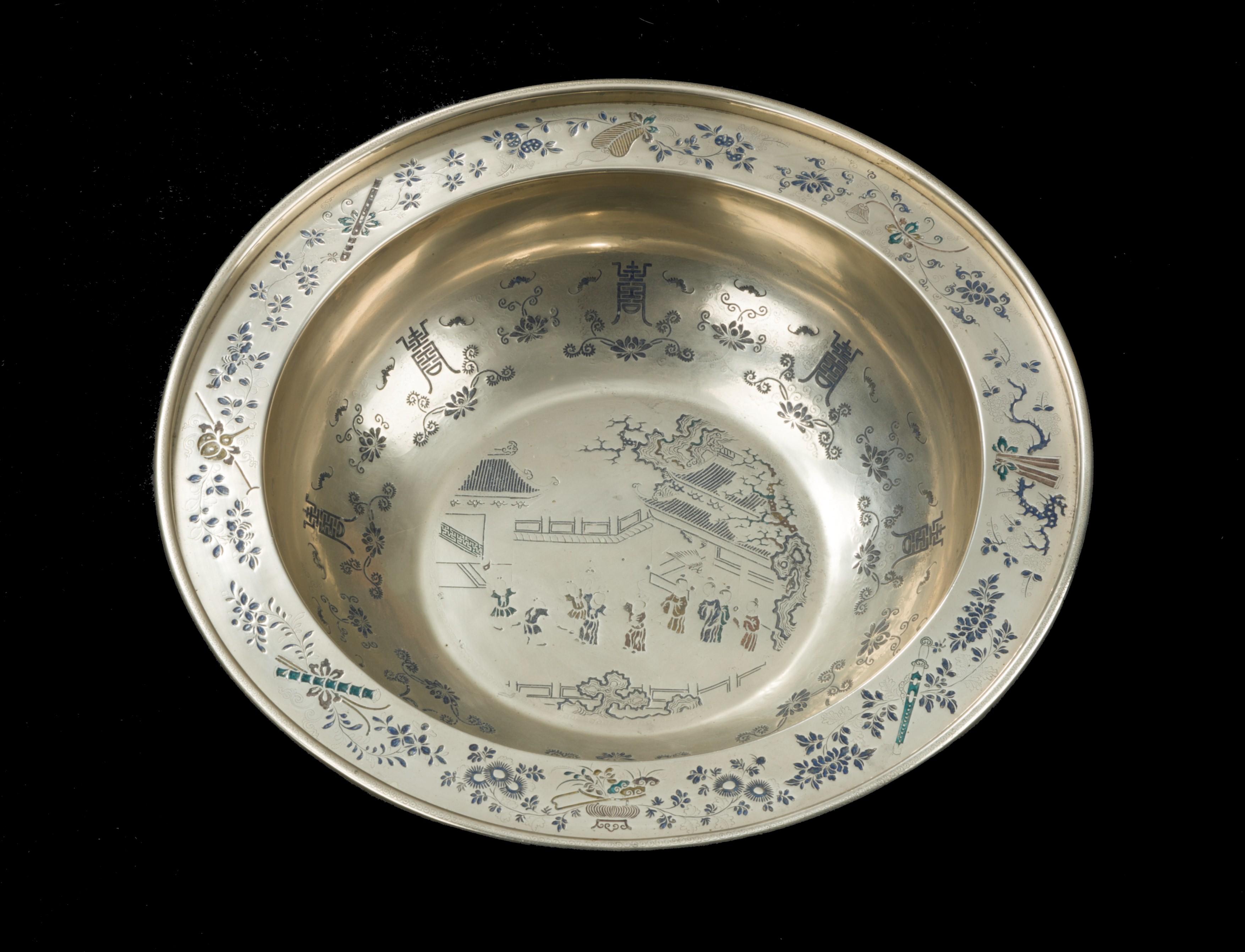 A Chinese paktong basin, engraved with scenes of many children at play and before pagodas, within borders of shou characters, bats and flowerheads, the flattened rim with vases of flowers and lingzhi, swords, lotus pods and other auspicious symbols,
