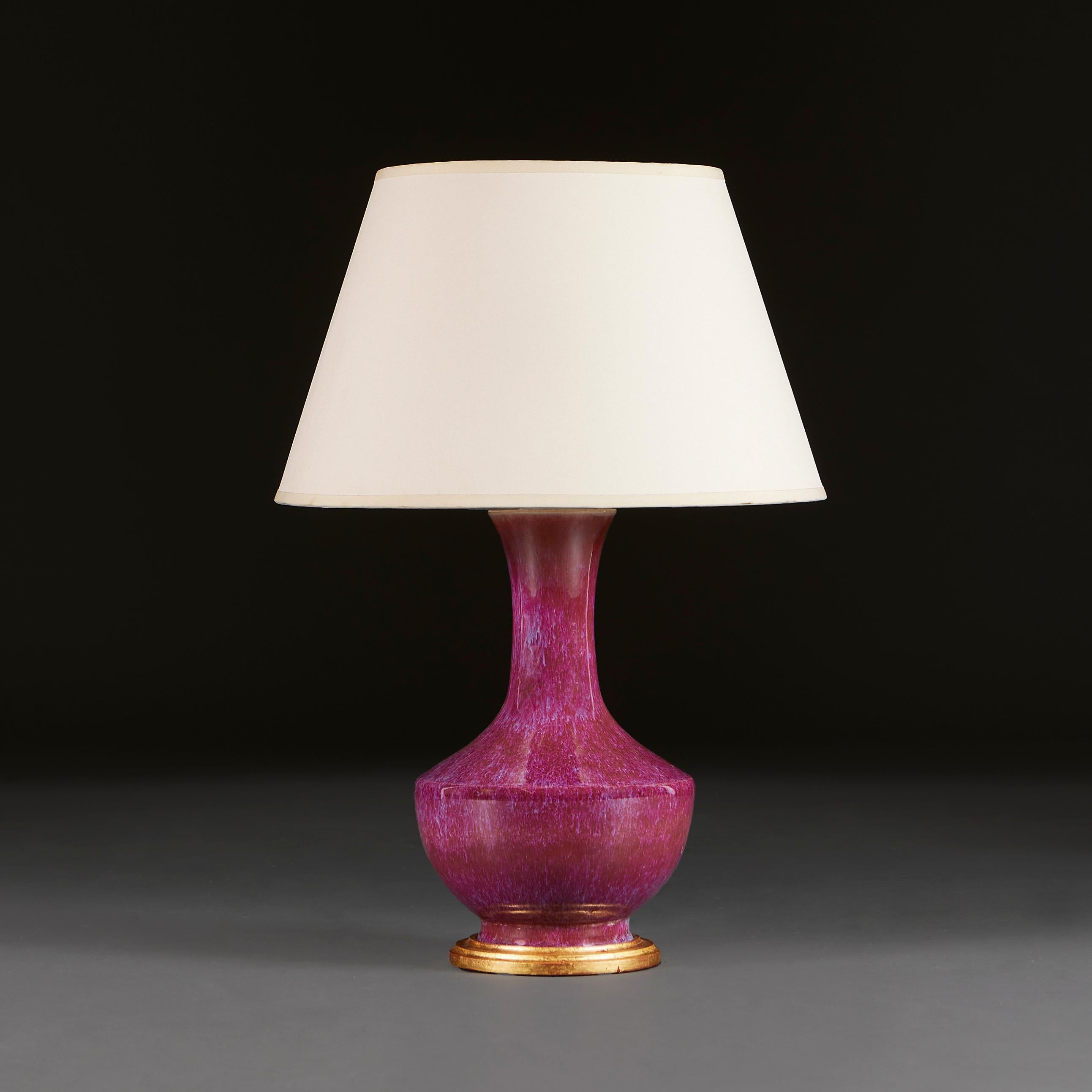 China, circa 1900

An early twentieth century Chinese Jun-Ware style vase with a flare elongated neck and tapering shoulders in a plum Flambé glaze, now mounted as a lamp on a giltwood base. 

Height 34.00cm
Diameter 23.00cm

Please note: This is