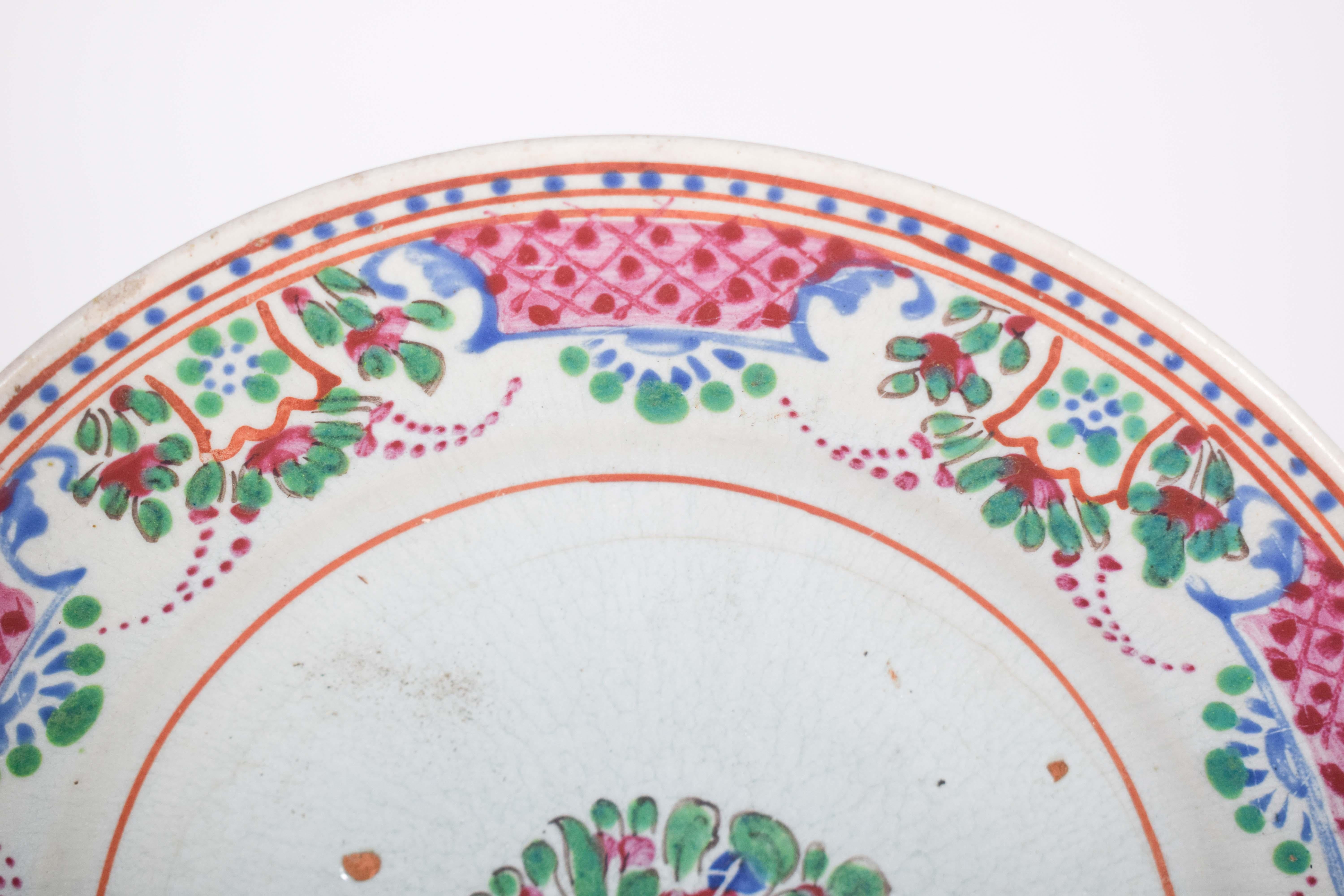 Chinese porcelain plate, with a refined and colorful design, reflects influences from 18th century European style, especially from French and German manufacturers, such as Sèvres and Meissen. The piece is decorated with a detailed floral pattern,