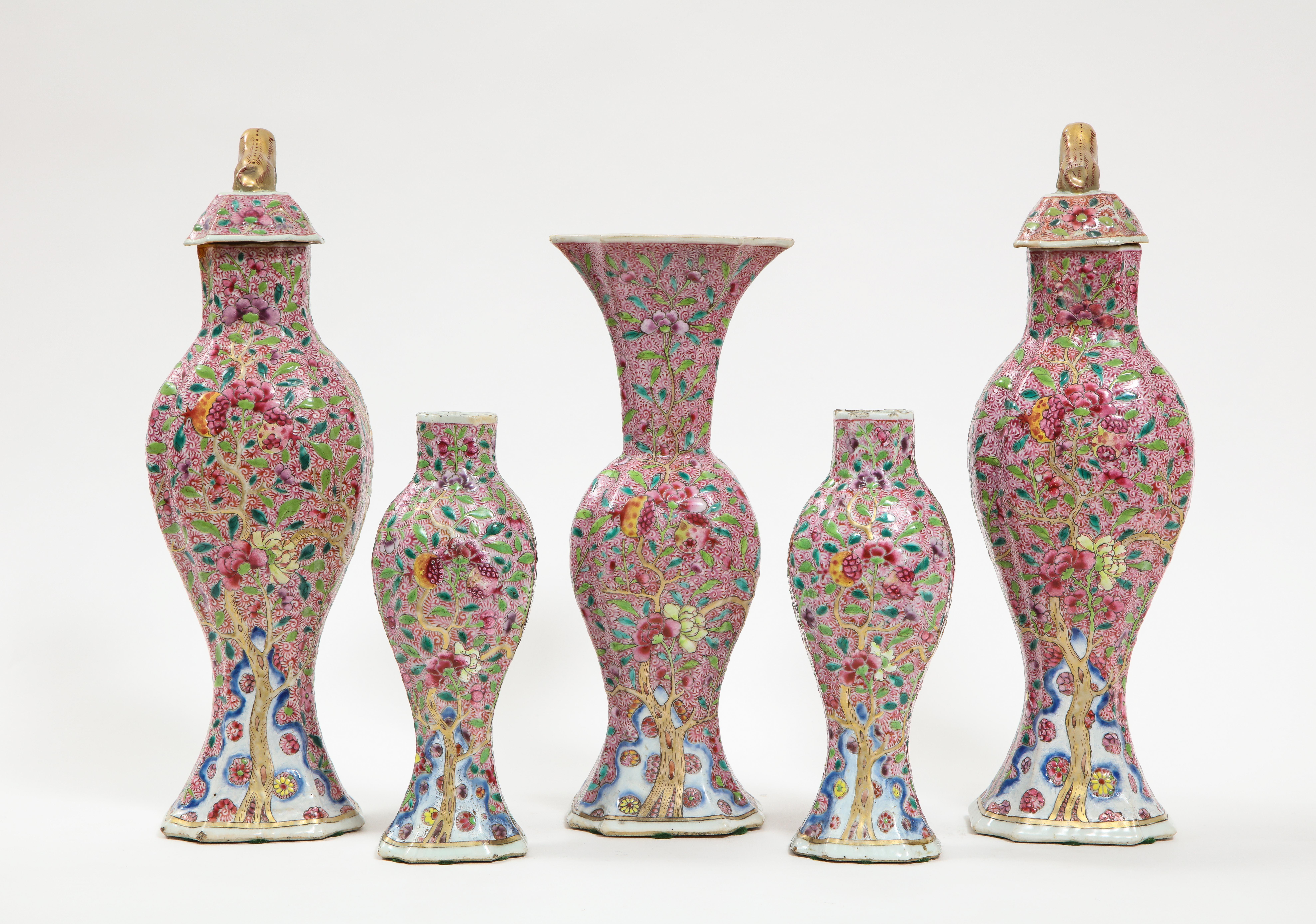 A 19th century Chinese porcelain famille rose puce ground five piece garniture set with floral designs. The five-piece set is complete with two large covered vases with gilt foo-dog finials, two smaller uncovered vases, and one mid-sized vase with a