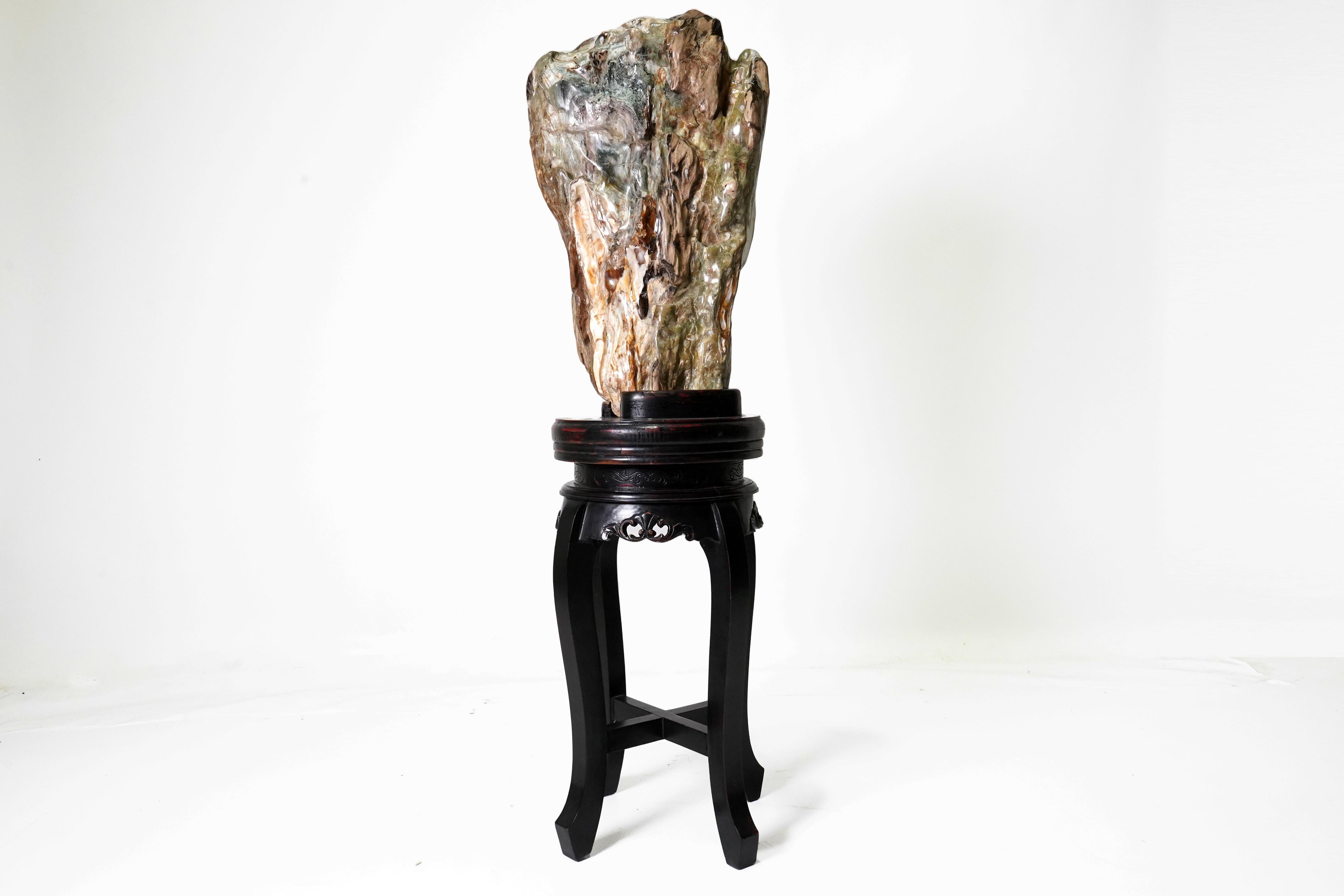 This impressive (and heavy) polished stone resembles a scholar's mountain as depicted in Chinese traditional paintings.  Though it has greenish areas that resemble jade, it is actually a complex colored marble.  The vintage piece has been fitted to