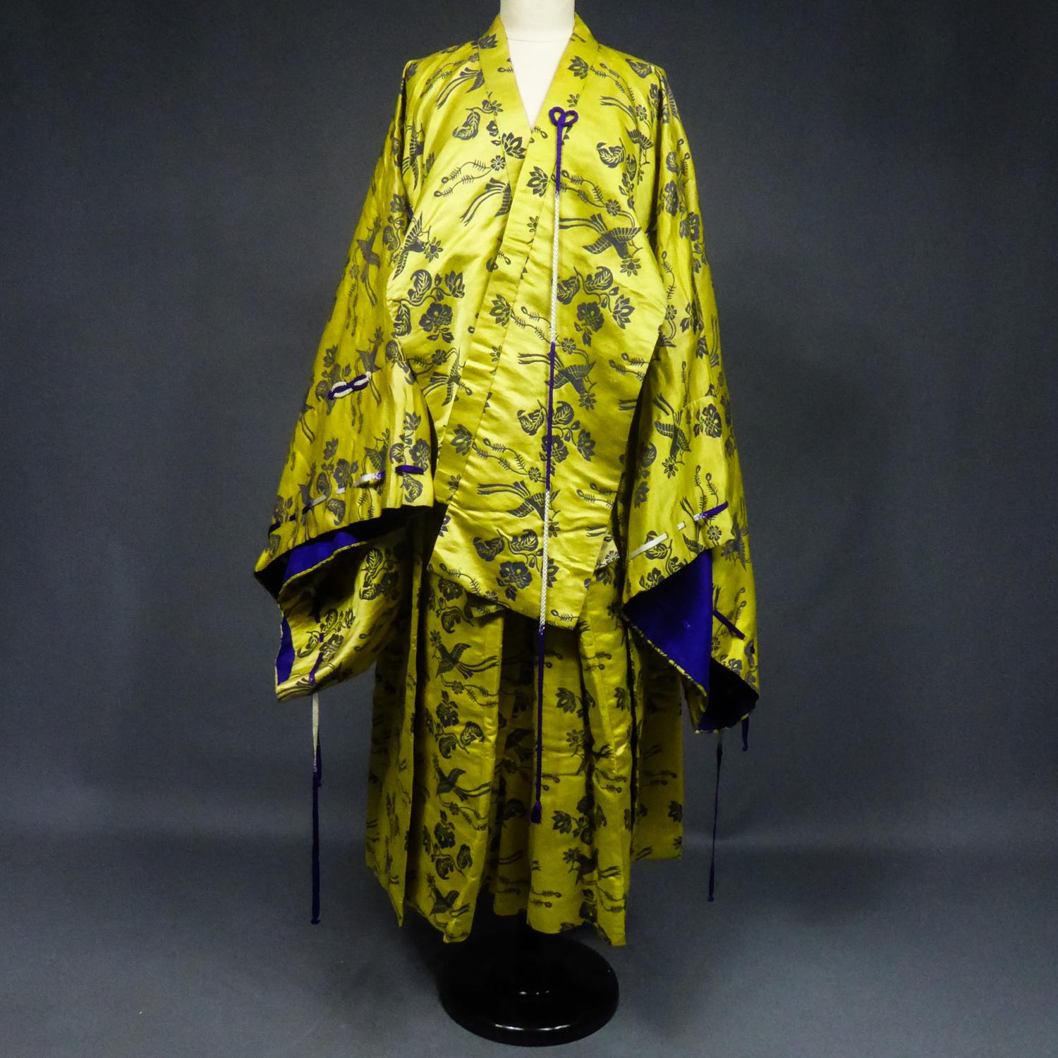 Circa 1960/1980
France

Étonnant ensemble dramatique chinois en satin damassé composé d'un kimono court et d'un pantalon sirwal de la seconde moitié du 20e siècle. Un damas en soie fine représentant des oiseaux et des fleurs stylisés apparaissant