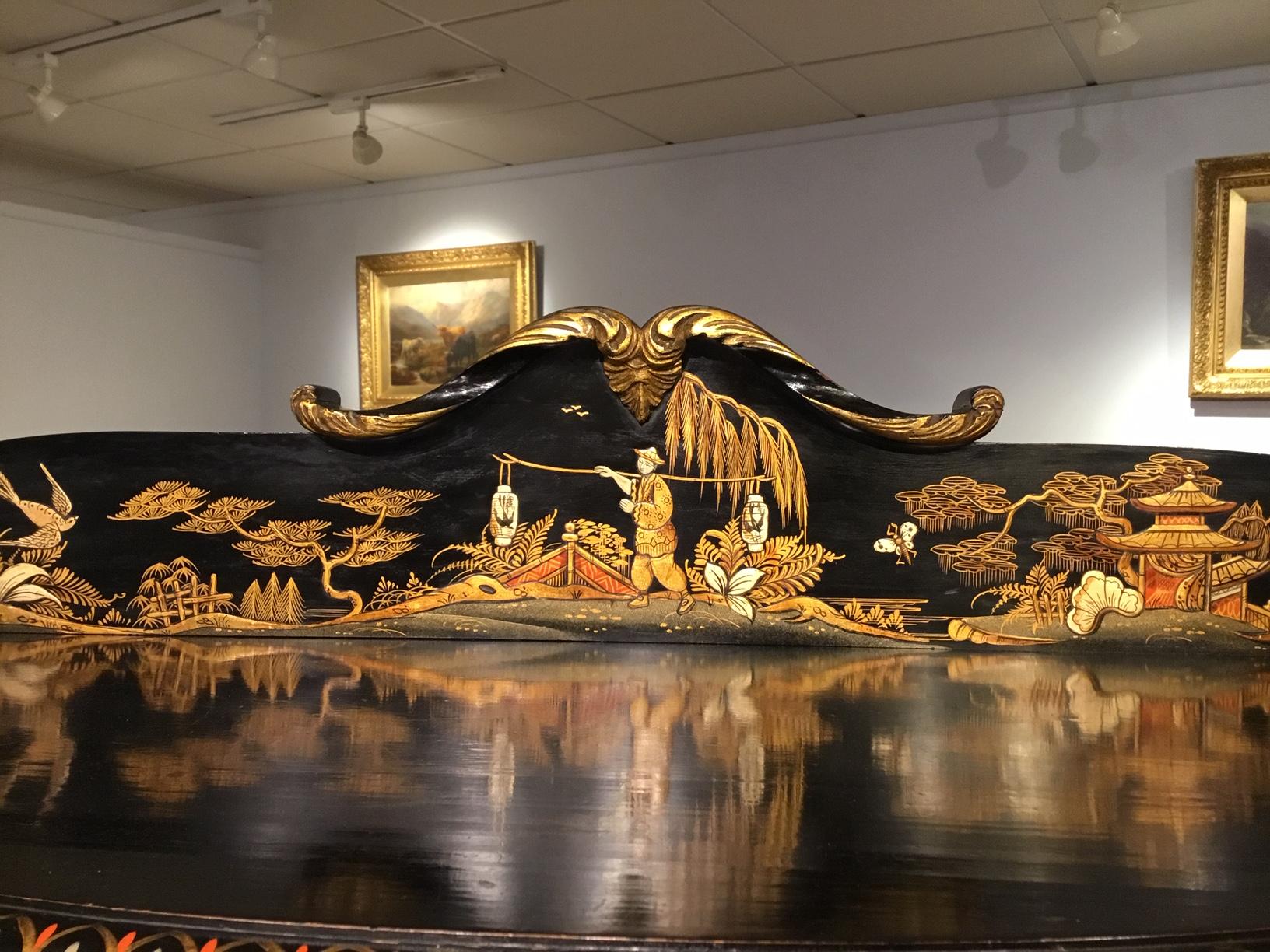 A chinoiserie 1920s Period lacquered display cabinet. The raised galleried back with a carved crest above a lovely gold lacquer panel depicting an oriental landscape. The demi lune cabinet also richly decorated with chinoiserie scenes. The central