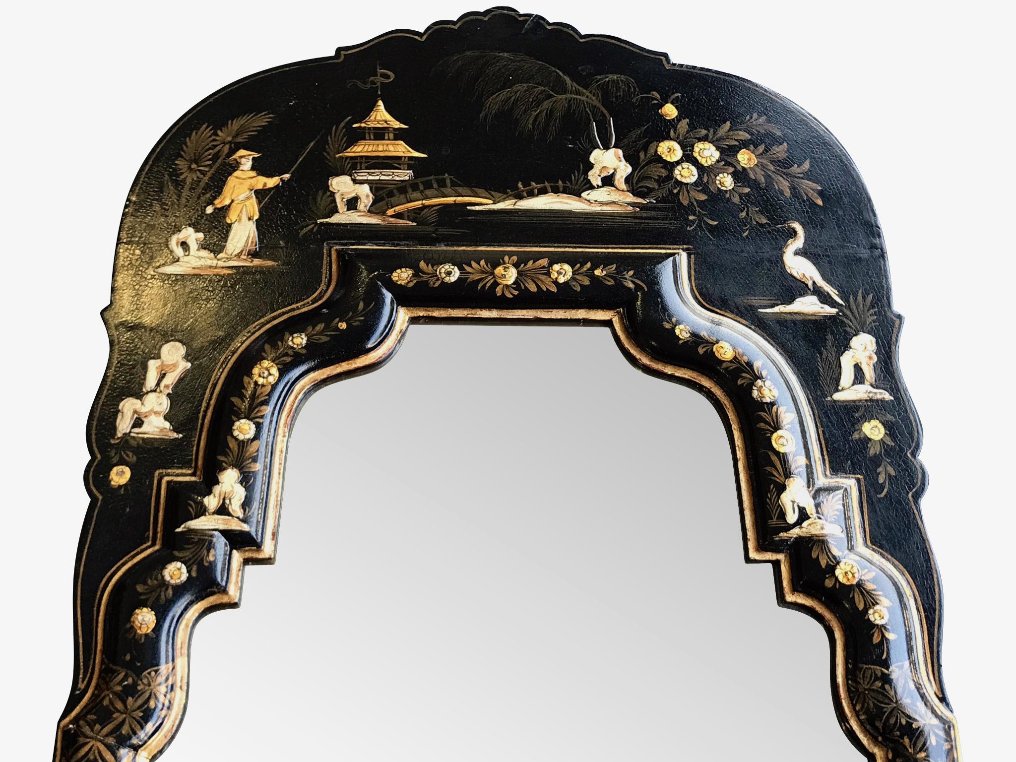 A chinoiserie mirror with arched top and black and gold lacquer frame with painted details of birds, figures and flowers in white and gold. With original makers label on reverse. 