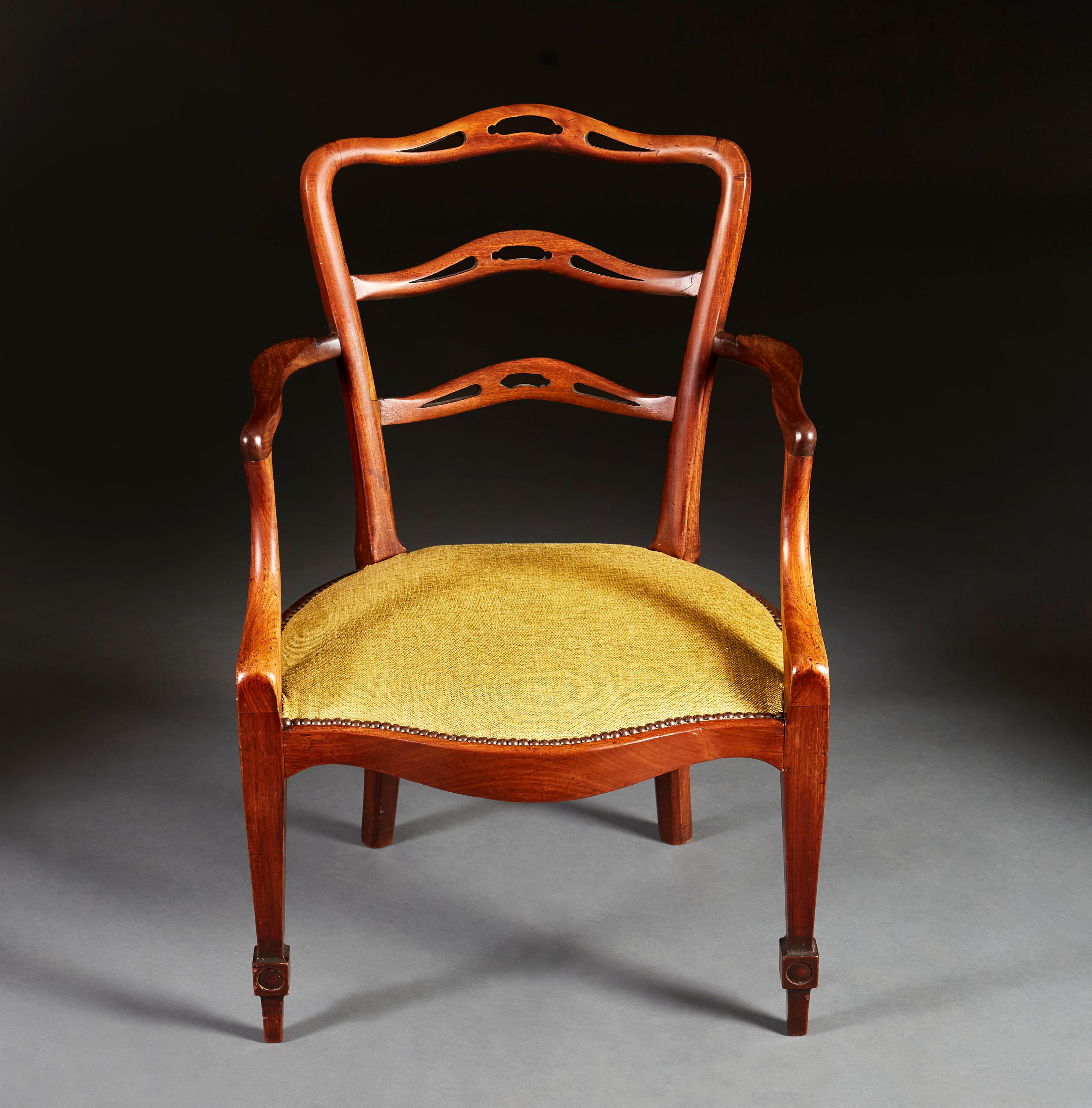 A mid nineteenth century Chippendale armchair with out swept arms, curved apron and pierced ladder back, all supported on tapering legs with carved medallion detailing to the front feet, recently upholstered in a green linen with patinated brass