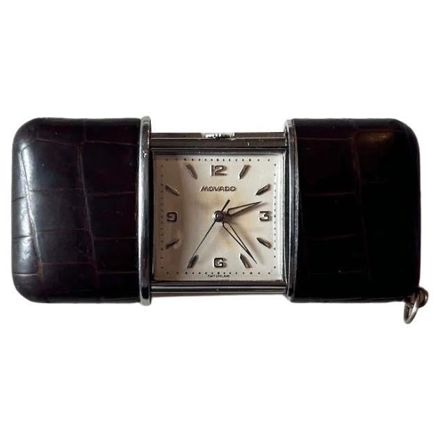 A ‘baby’ Movado purse or travel watch. Chocolate brown crocodile skin with silver mounts.
1950s, in excellent condition with code numbers punched on the back of the case and the original silver strut, movement running well.
Size open: 68mm x38mm.
