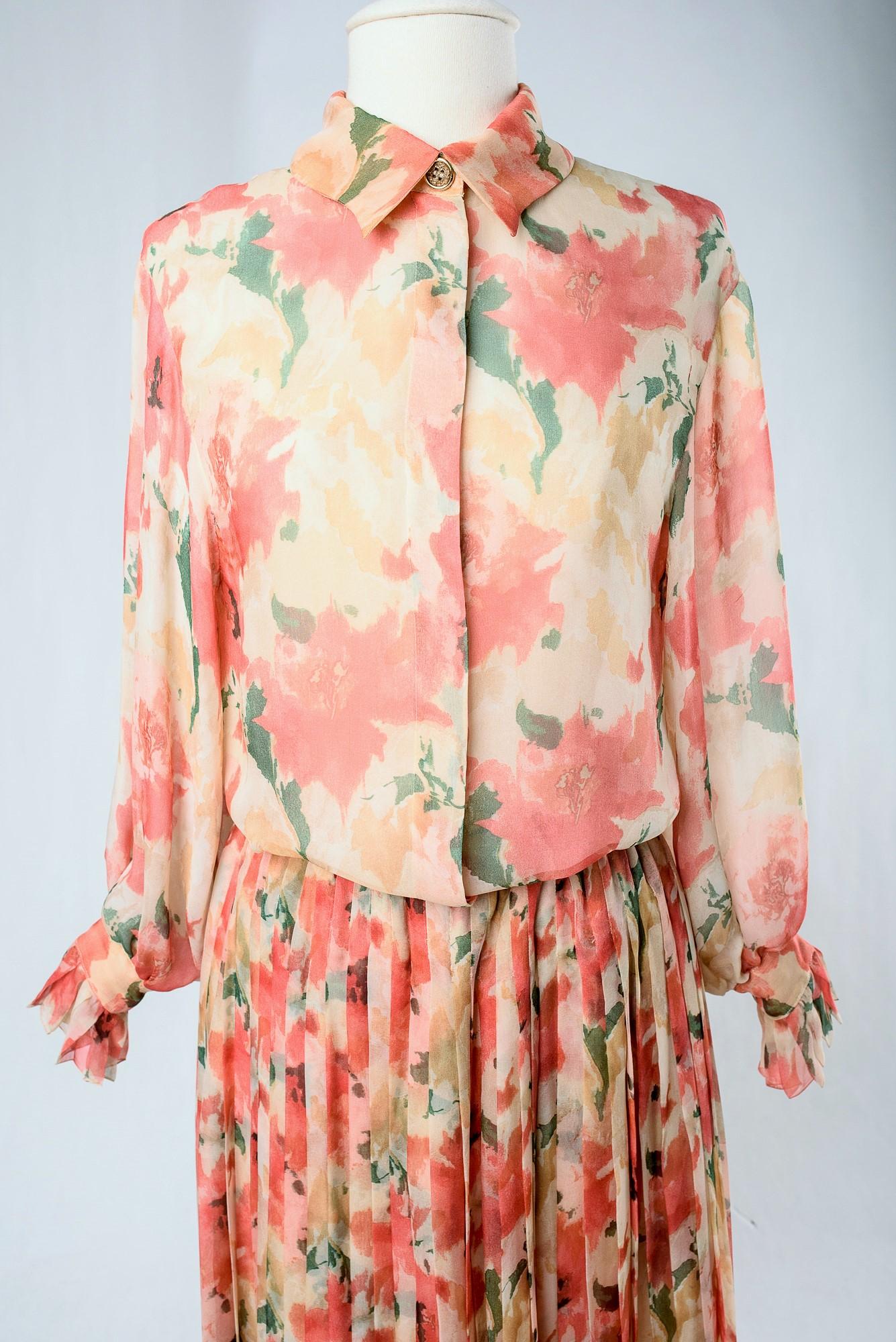 Circa 1980 Francia
Romantico set di camicetta e gonna di Christian Dior Boutique sotto la direzione di Marc Bohan e risalente agli anni '80. Crêpe di seta traslucida stampata con motivi floreali impressionisti in tonalità rosa, salmone, verde e
