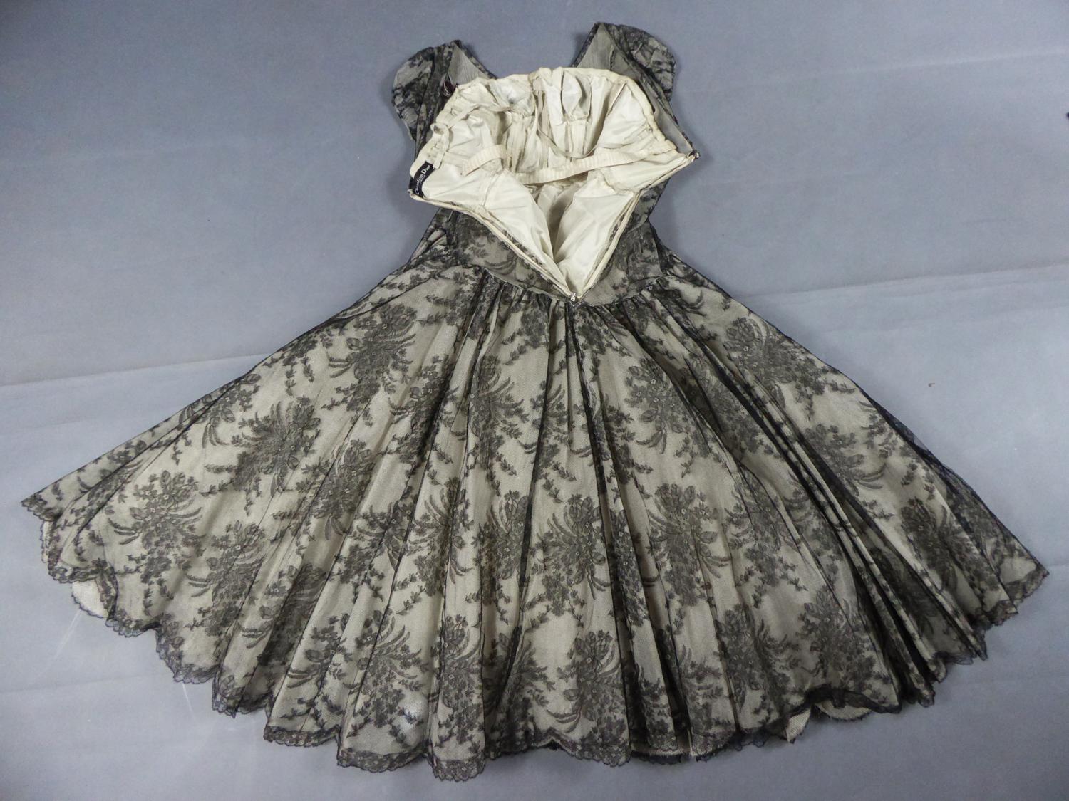 Ligne Oblique Collection (?) Circa 1948/1950
Paris France

A Collectible Calais black lace cocktail or ceremonial dress by Christian Dior. Black and white transparency effect obtained by superimposing a black bouquets lace on a cream taffeta lined