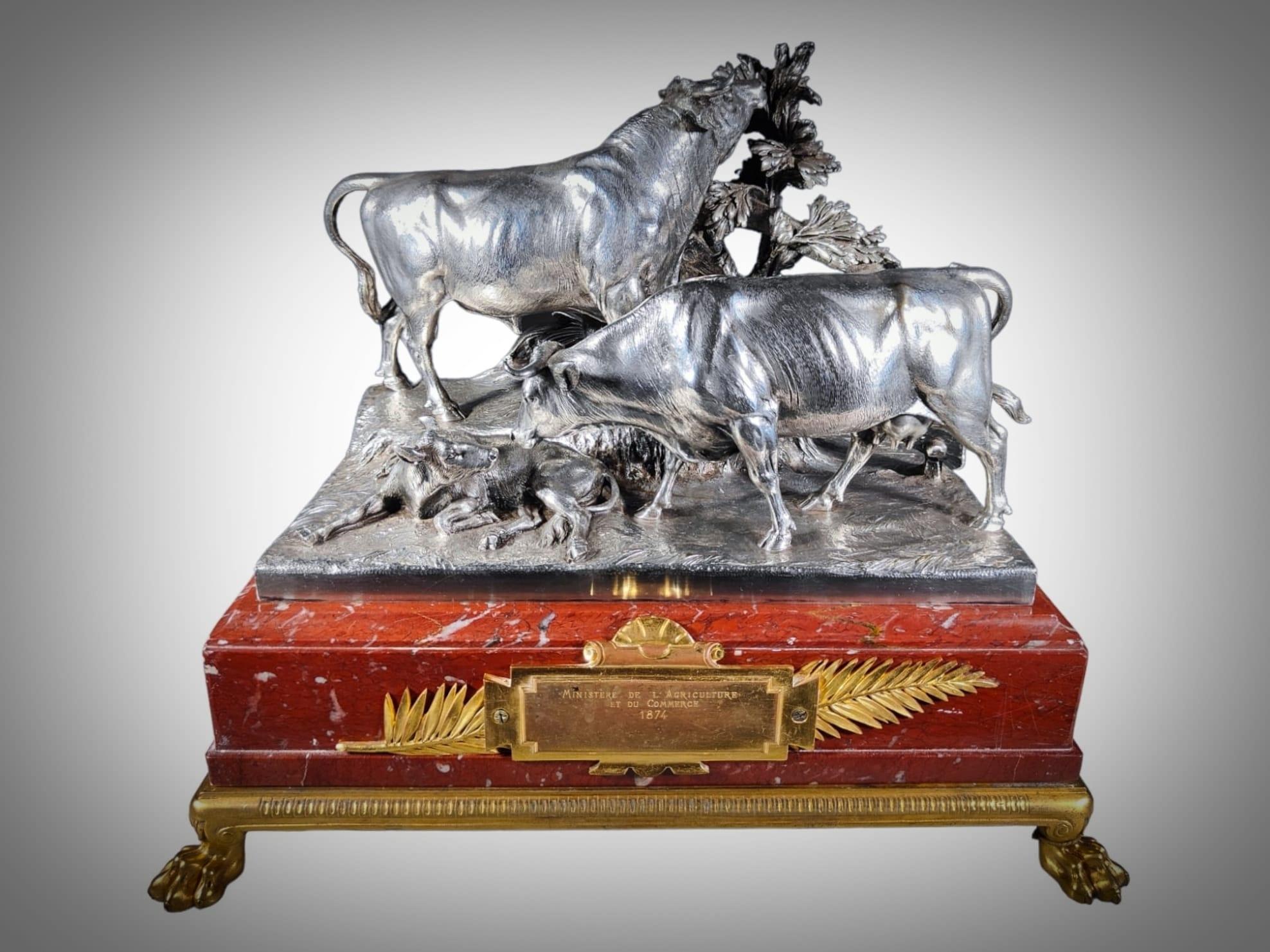 A Christofle & Cie Silverplated Bronze Presentation Group Of A Bull, A Cow And A Calf Paris 1874
Incised Christofle & Cie on a rouge royale marble base with a gilt bronze plinth and feet, with an inscription plaque inscribed MINISTERE DE