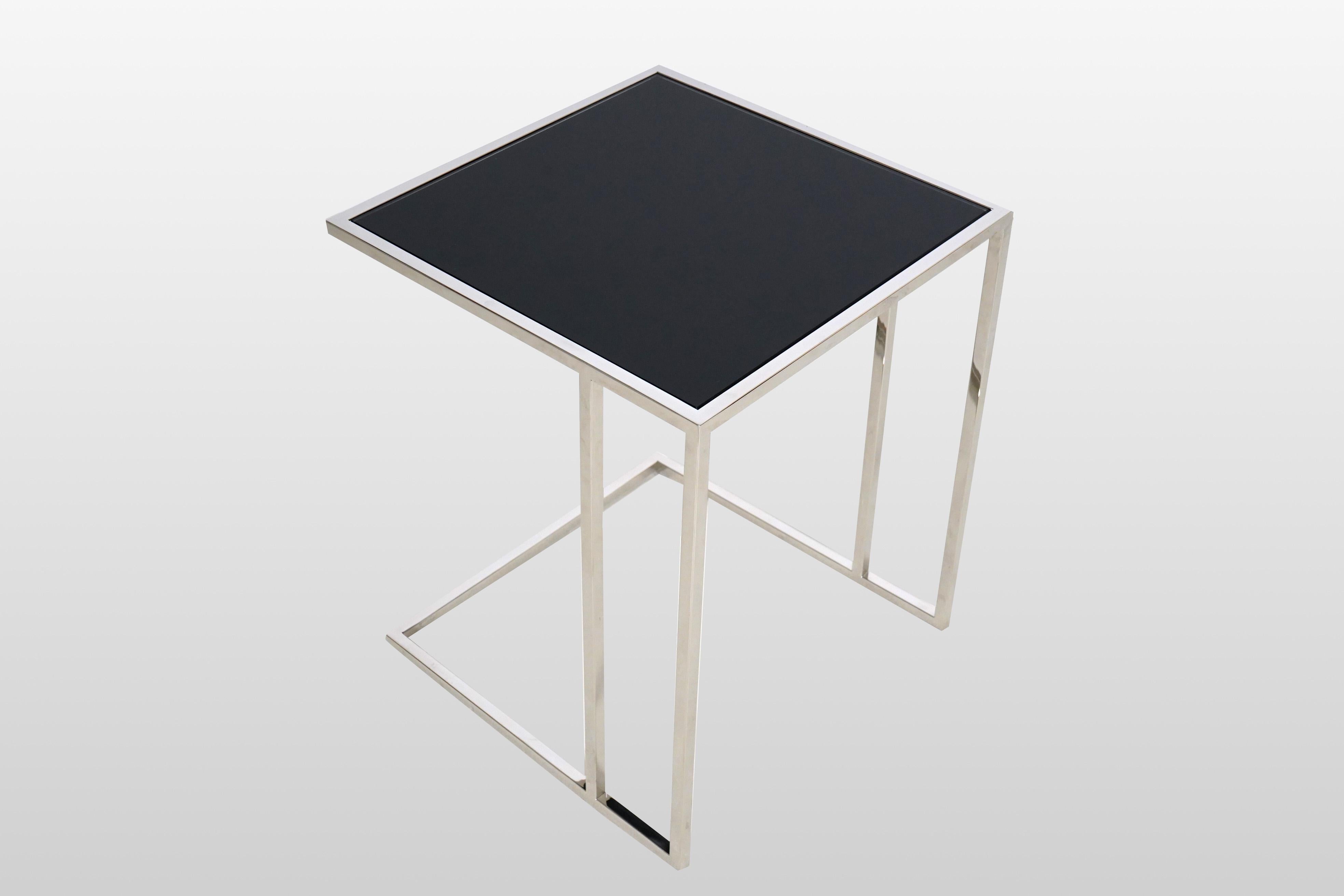 Cette table d'appoint très moderne et anguleuse s'inspire des designs italiens des années 1960. Le cadre en chrome poli est très fin et minimaliste et a été associé à un plateau en verre fumé. La pièce constitue une excellente table d'appoint et