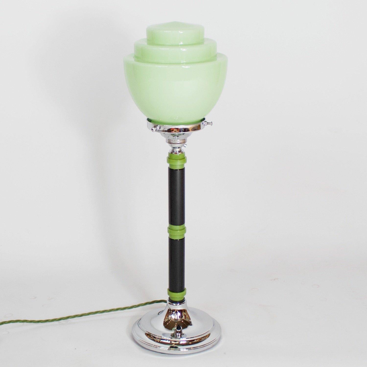 A chromed metal, bakelite and glass Art Deco table lamp. Two toned green bakelite stem with a chromed metal base and green glass stepped shade. 

Dimensions: H 50cm D of shade 15cm D of base 13cm

Origin: English

Item number: 1706205

All