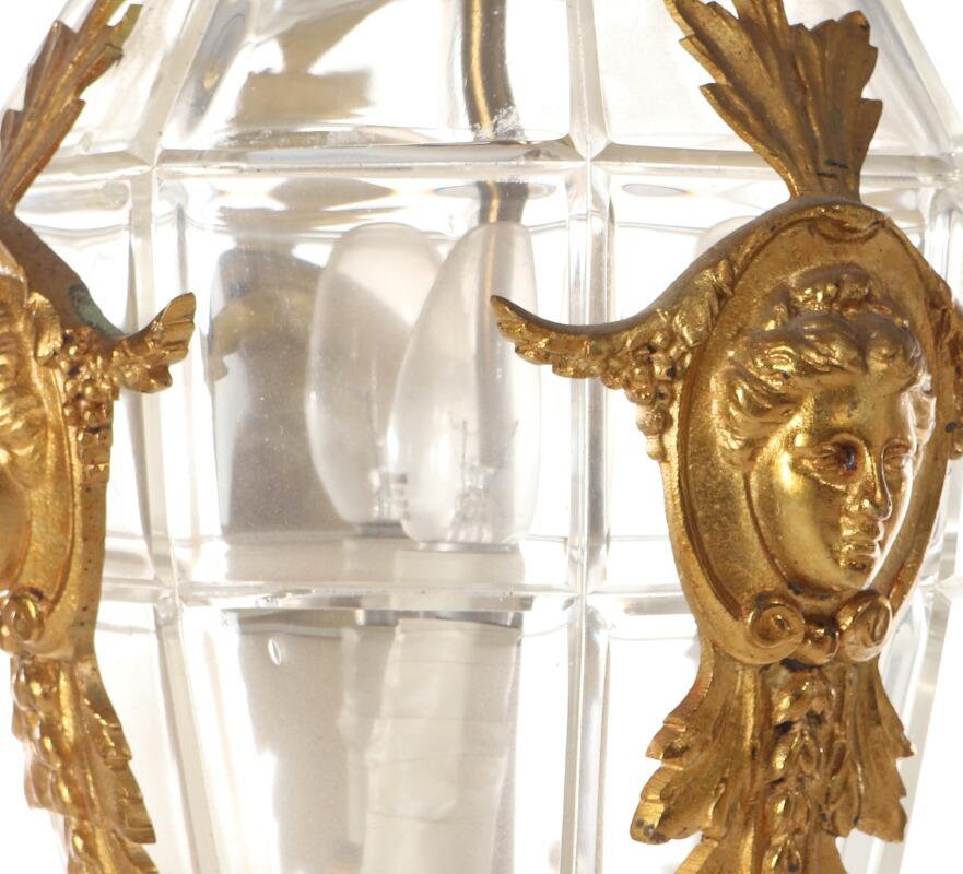A circa 1900 gilt bronze hall chandelier, richly cast with masks and foliage.