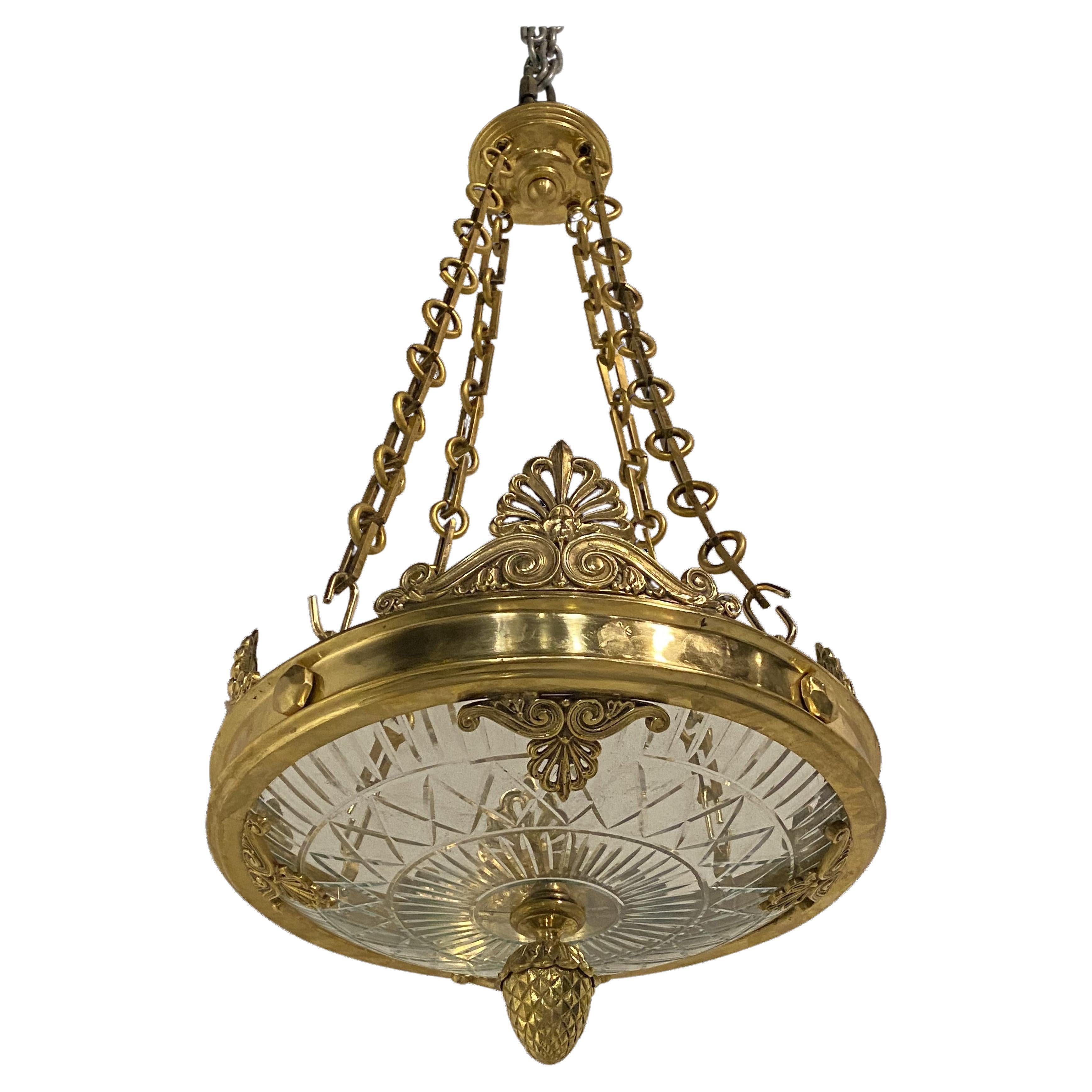 Un luminaire en bronze doré de CIRCA datant des années 1920 avec un insert en verre taillé. (6 lumières intérieures)