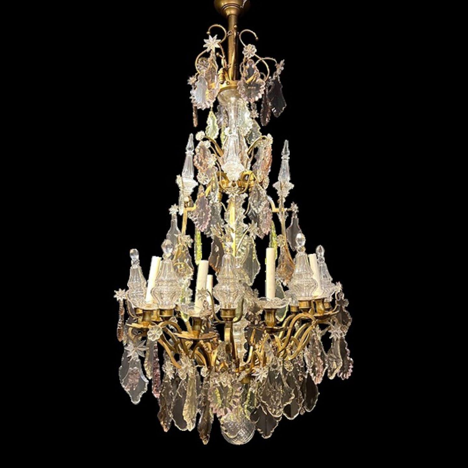 A circa 1920’s large bronze chandelier with different color crystal pendants, with 8 lights and 8 interior lights