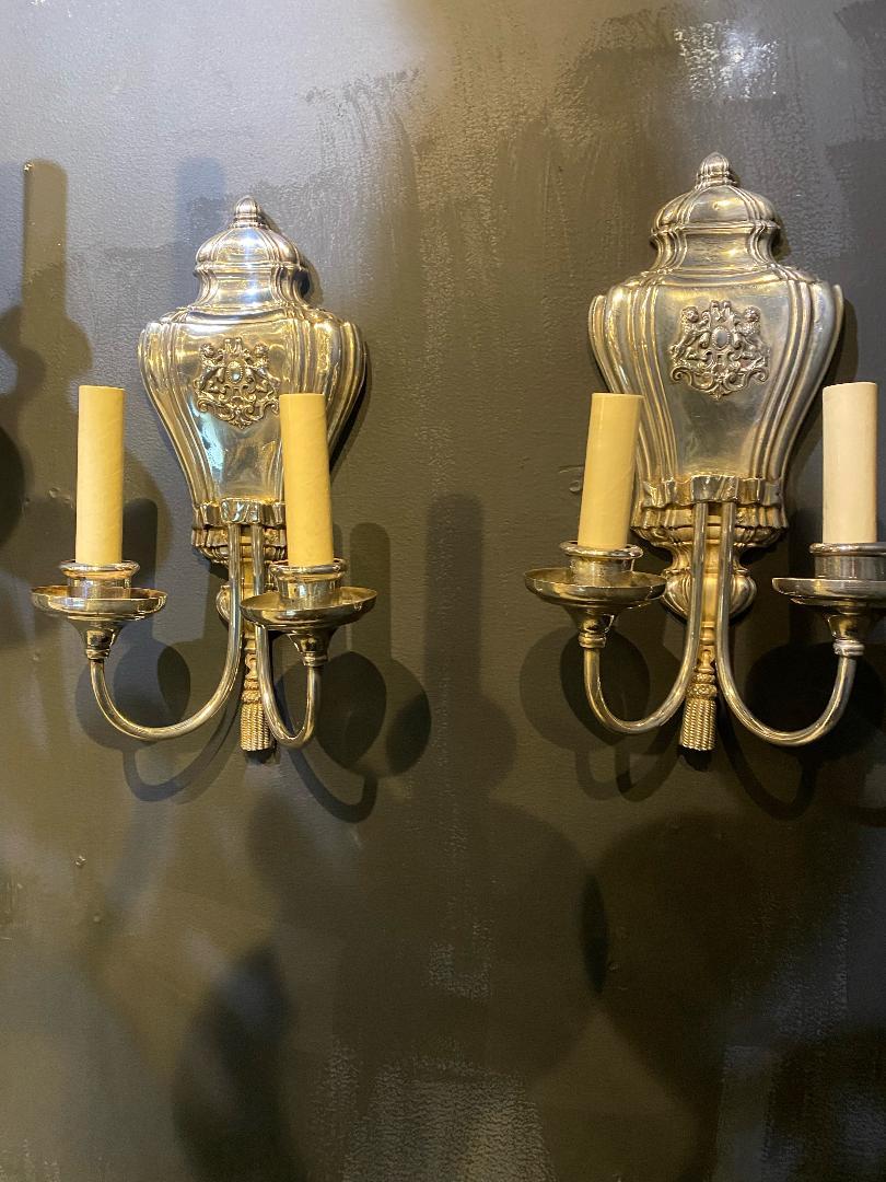 A pair of circa 1920's Caldwell sconces, silver plated finish with rampant lions' crest design. *8 pairs available.