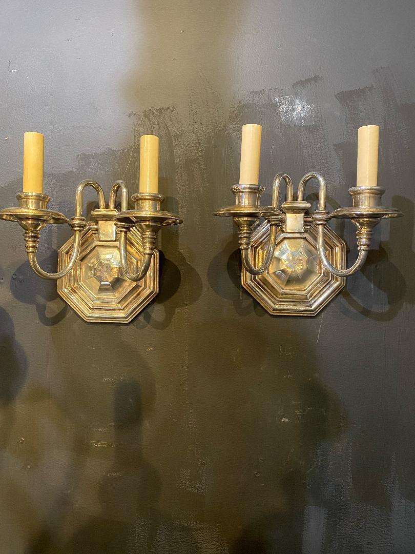 A pair of circa 1920's Caldwell double light silver plates sconces