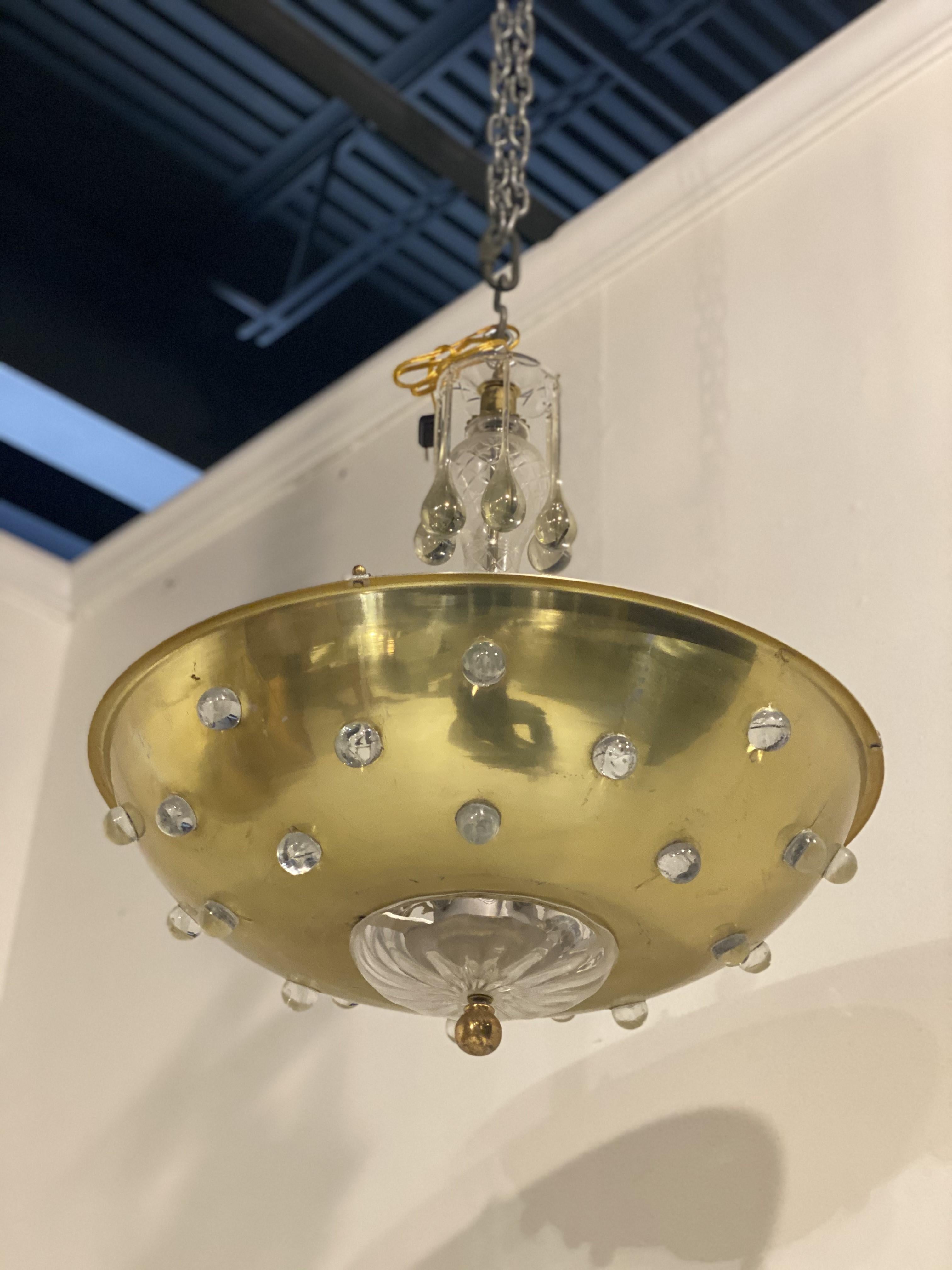 A circa 1940's Austrian gilt bronze light fixture with crystal body atop and crystals on bronze plate, with interior lights.