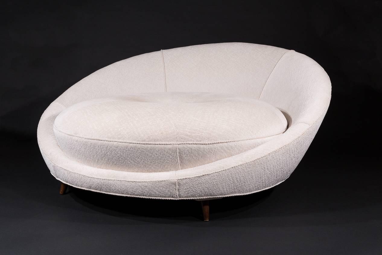 A beautiful circular sofa by Milo Baughman upholstered in a textural off-white fabric. A very cool mid-century modern piece of furniture.