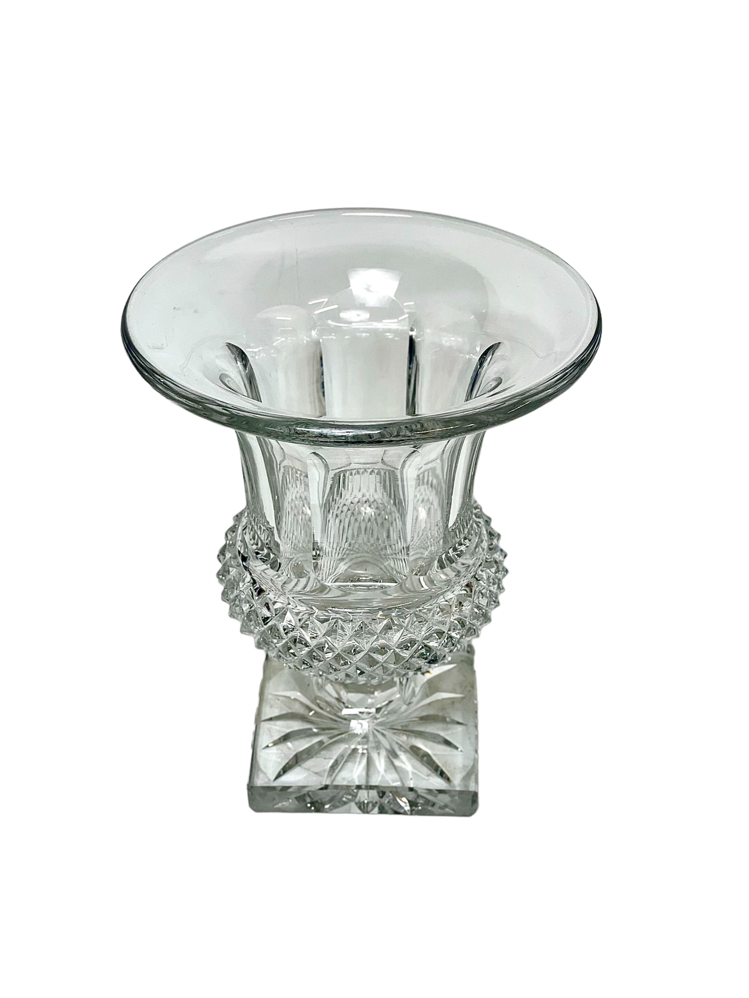 Vase de style Médicis en cristal taillé classique de Saint Louis, dont la partie inférieure est taillée en pointes de diamant à larges facettes et la partie supérieure élégamment cannelée. Le vase repose sur une base carrée substantielle, taillée en