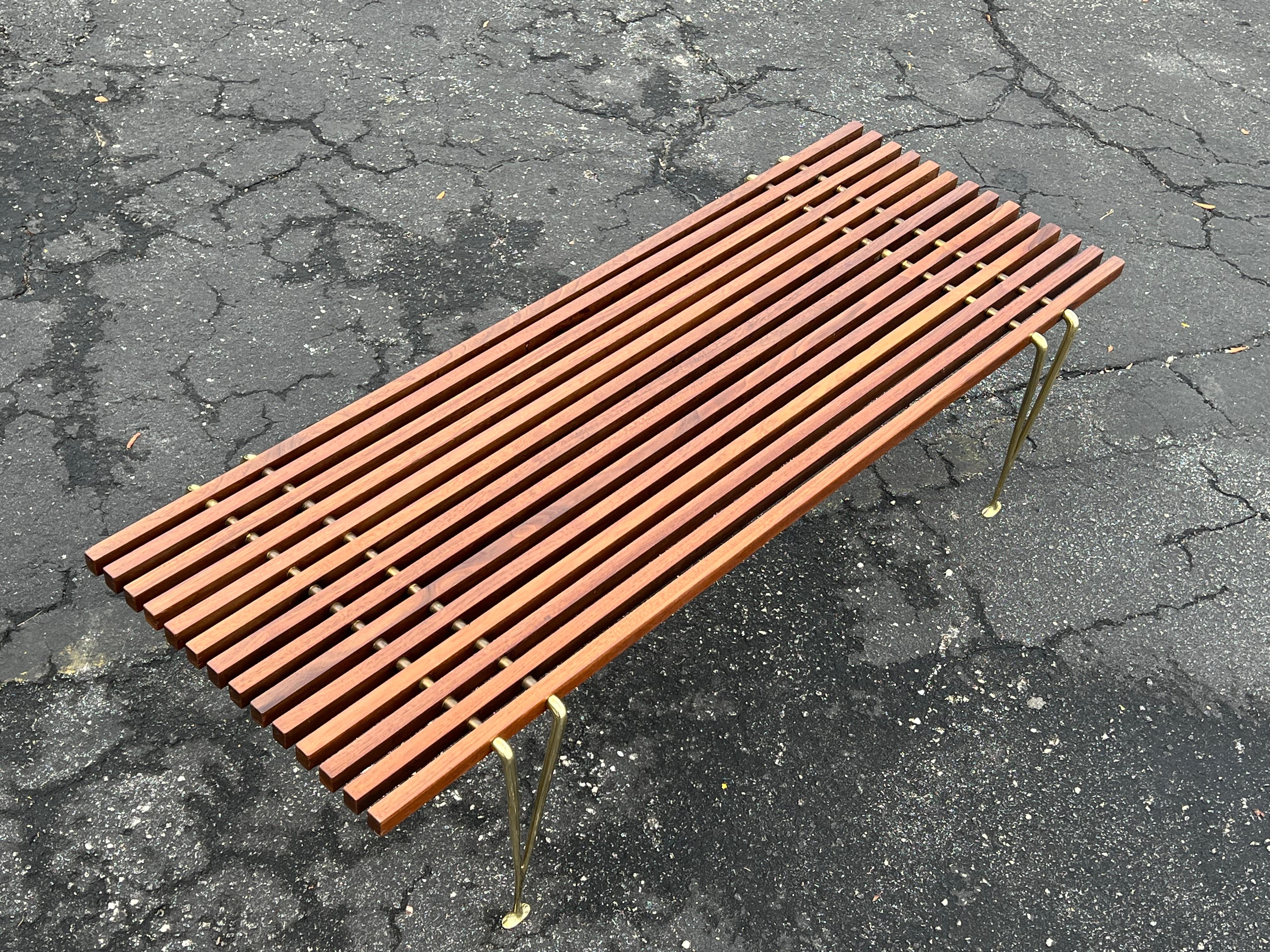 A classic Hugh Acton slat bench ca' 1950's. Solid brass Y shaped legs and slats make this a design favorite.