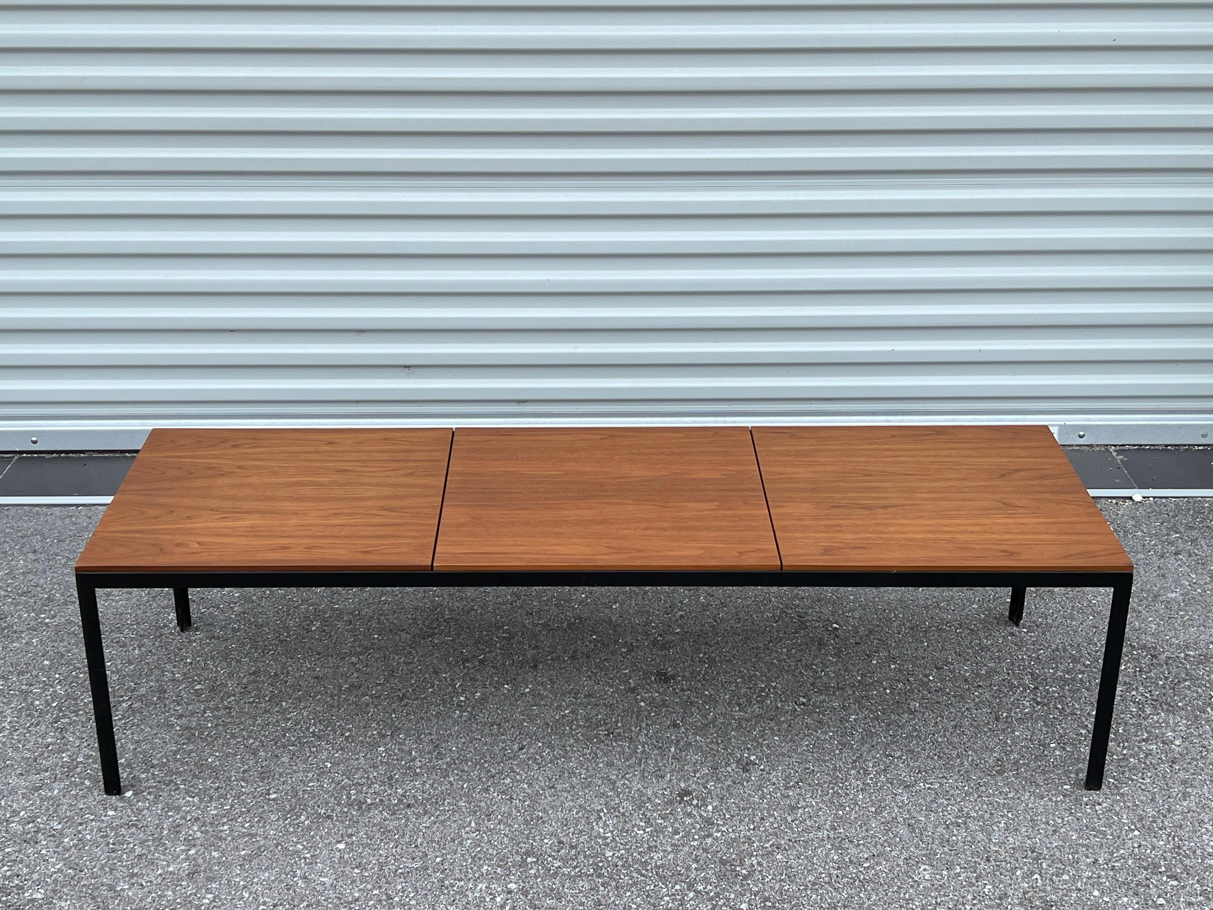 A classic bench or coffee table by Florence Knoll. Manufactured by Knoll ca' 1960's.  Beautiful  walnut veneer, quality early Knoll production. Very practical and timeless, minimalist design. Heavy angled T iron frames-each one weighs over 80 lbs. 