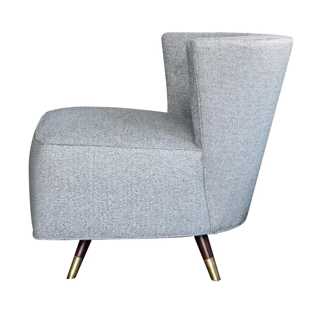 Each with incurved wedge-shaped tufted back above a generous seat all raised on turned wooden legs with brass sabots.