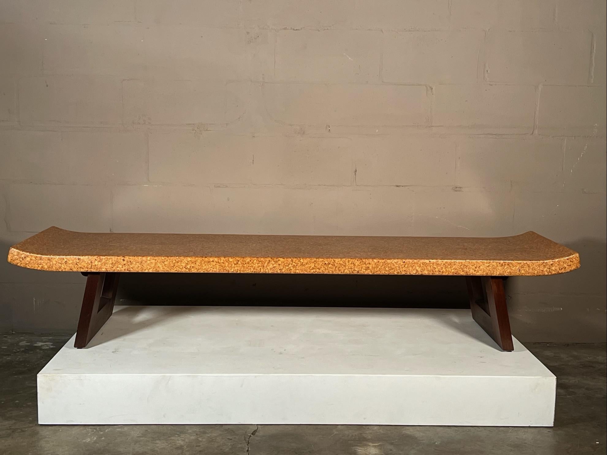 A classic cork top bench by Paul Frankl, in natural finish. Splayed legs with cut outs, raised ends.