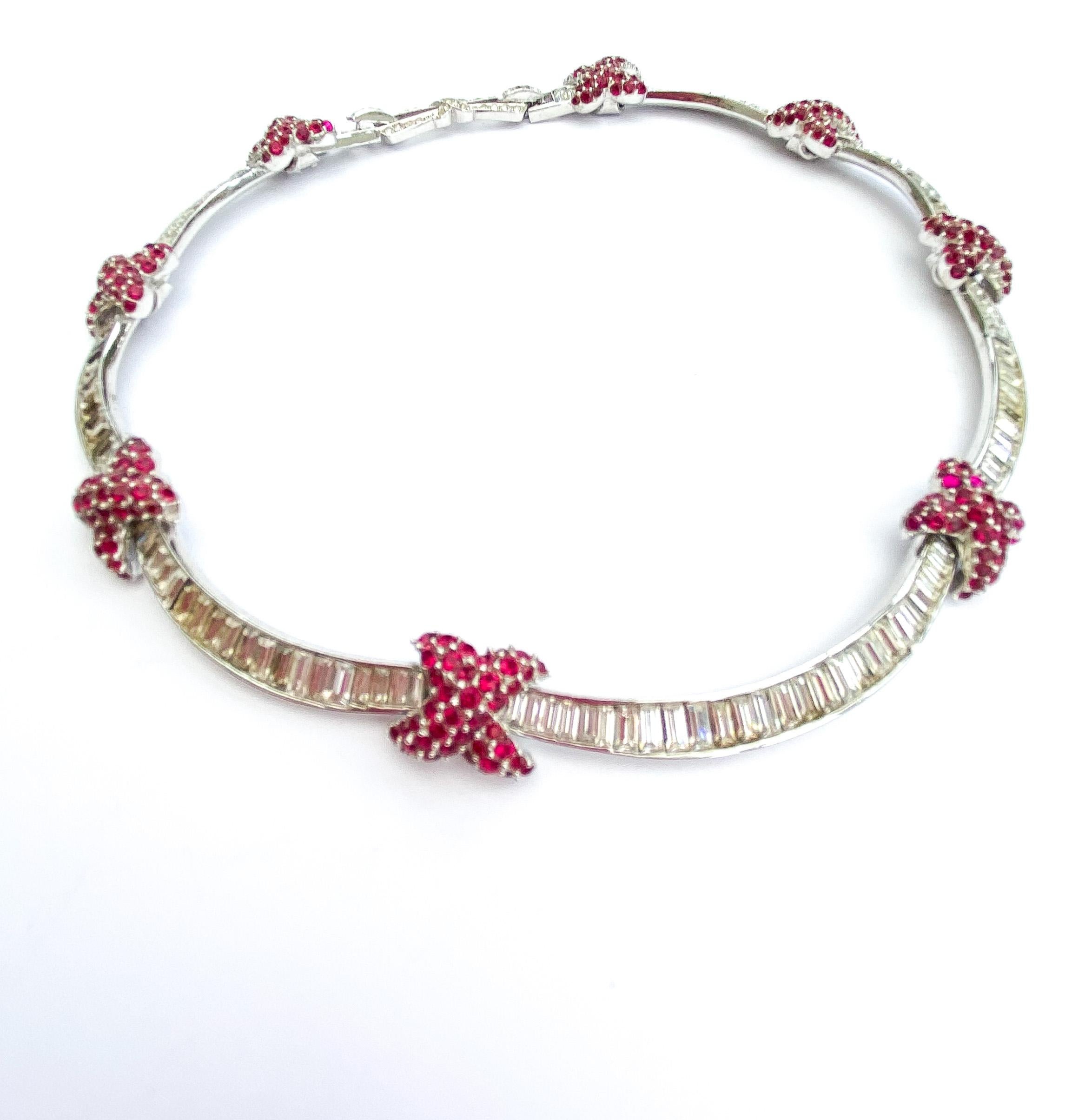 An exquisite and finely crafted ruby and clear paste necklace designed by Marcel Boucher in the 1960s. It has the unusual feature of a 'double clasp' at the back, the mid section in the form of a bow, the clasp allowing the wearer to shorten or