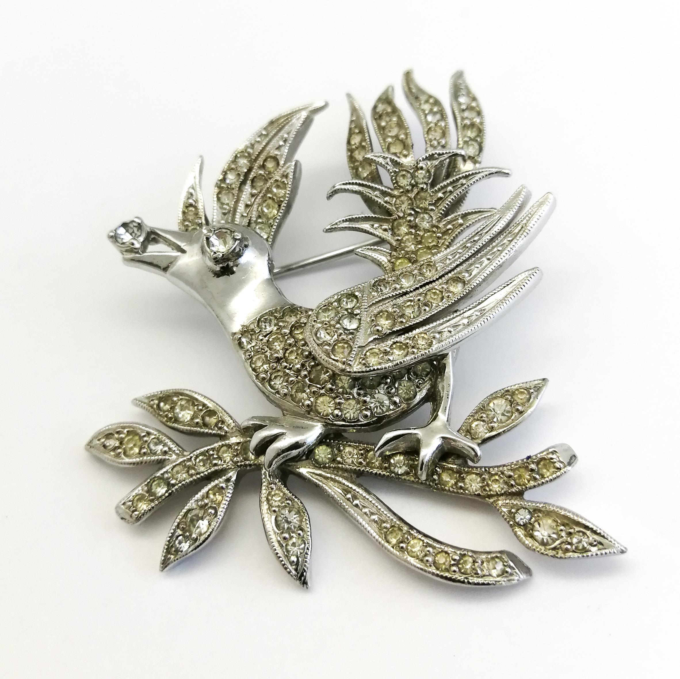 This beautiful 'gem' of a brooch, represents a bird, sitting on a branch, holding a single 'jewel' or 'diamond' in its beak. Beautifully crafted in rhodium metal and clear paste by Mitchel Maer for Christian Dior in the early 1950s, it is a part of