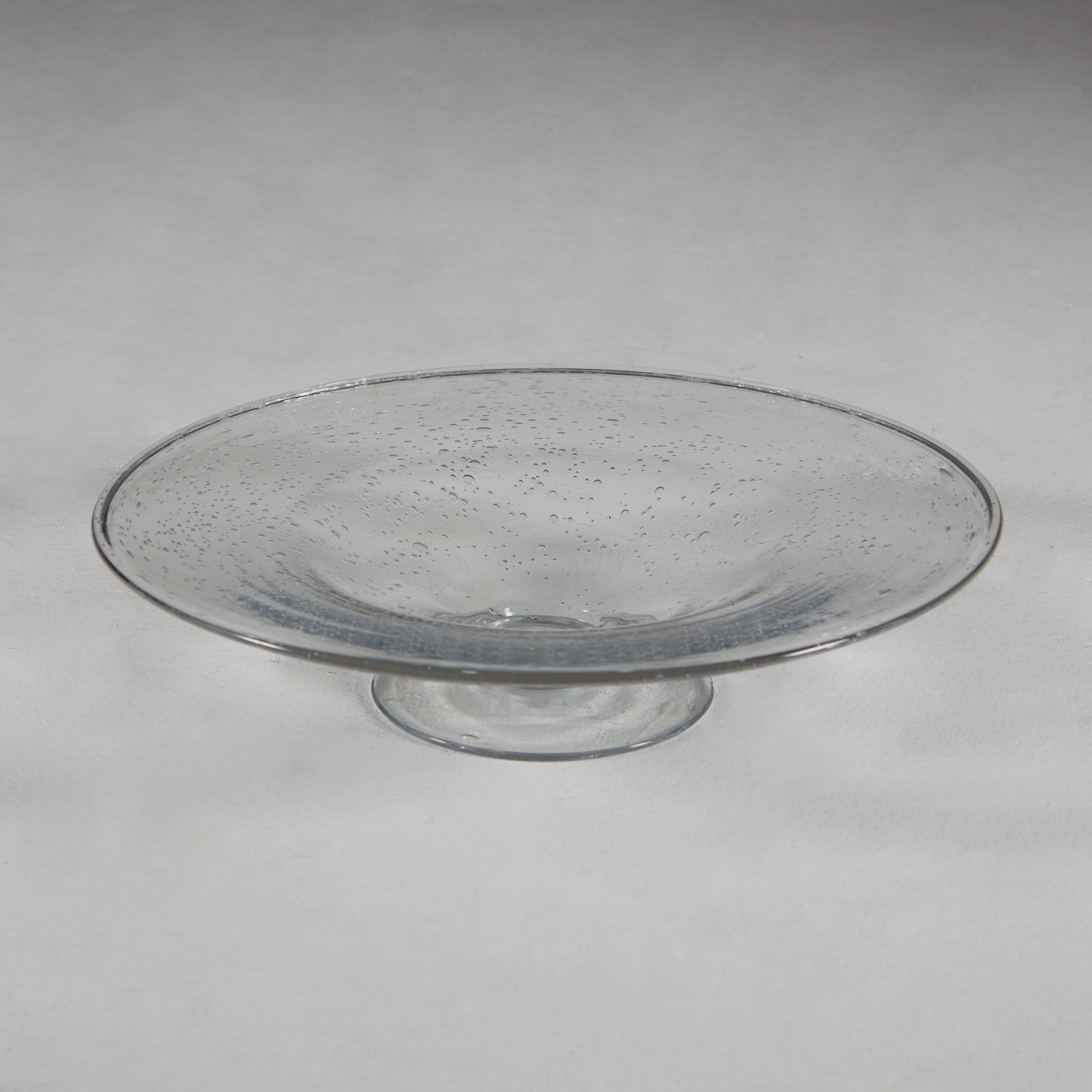 A mid-20th century clear Murano glass dish with stand, the Pulegoso technique used to create tiny air bubbles throughout.

Carved wooden fruits not included.
