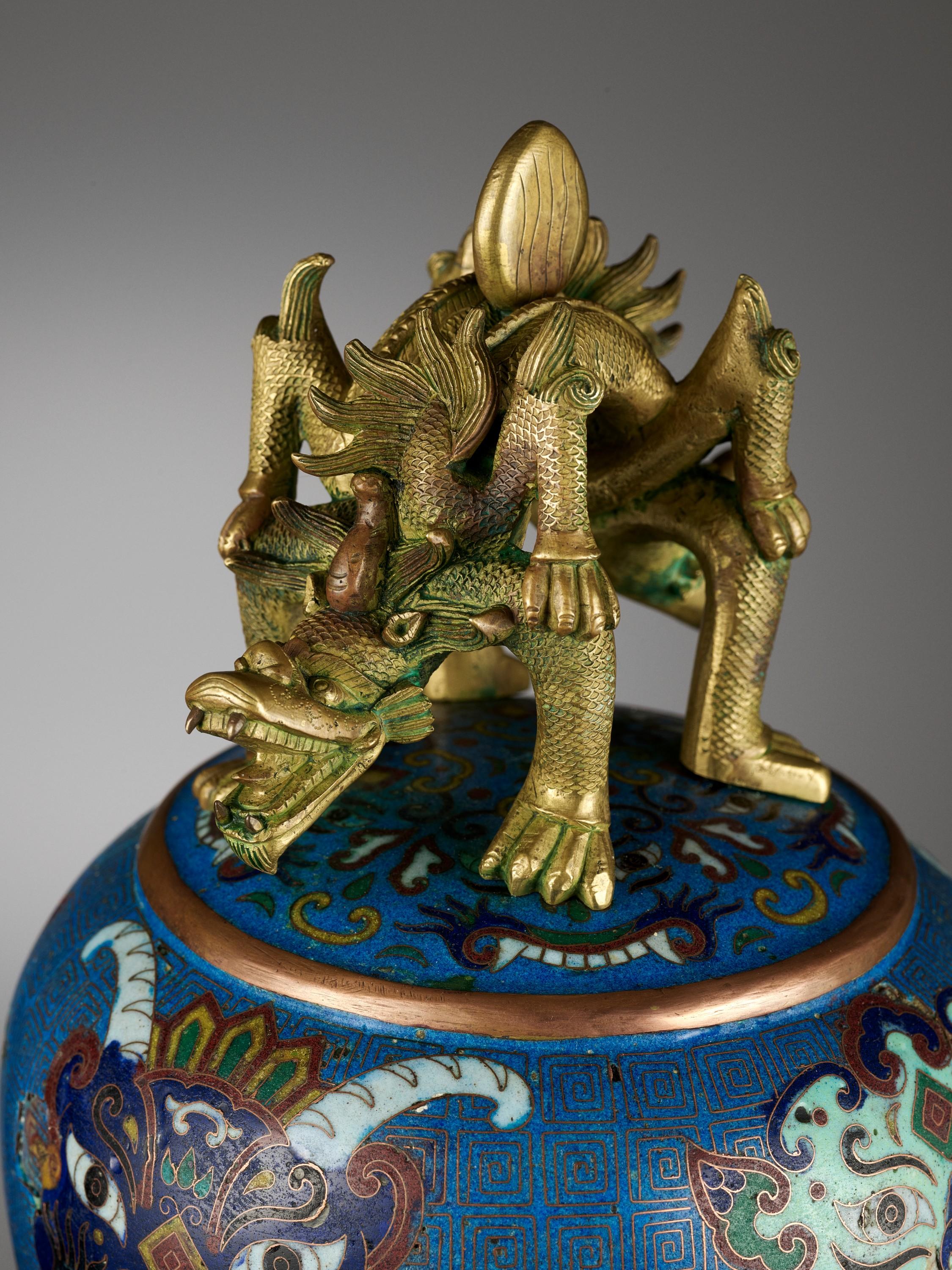 A cloisonné enamel bell, China, Qing Dynasty, 18th-19th century

Of flared form with a lobed bottom edge, an upper register of elaborate taotie masks on a key fret ground above stylized chilong, and a lower register of taotie masks and archaistic