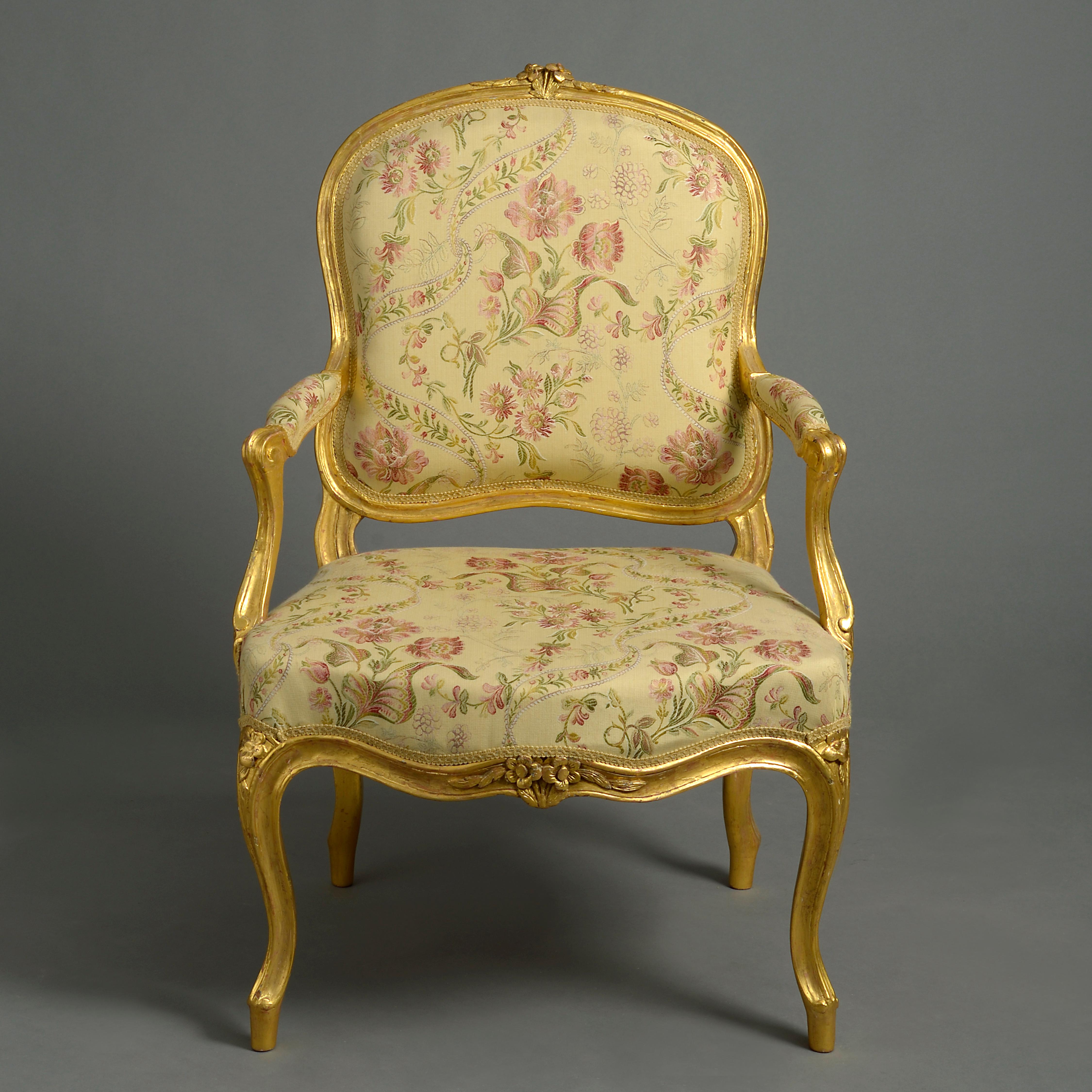 Due fauteuils o poltrone aperte in legno dorato del periodo Luigi XV della metà del XVIII secolo, ciascuna con schienale a cartiglio, sormontato da un intaglio floreale, braccioli a voluta e telai sagomati, tutti sollevati su gambe cabriole.
