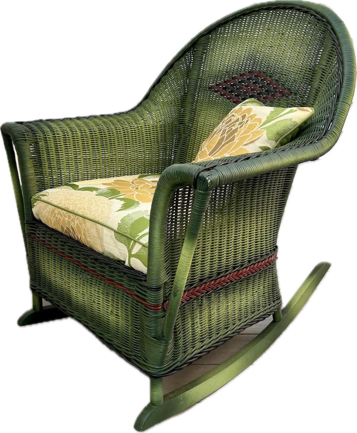 A beautiful close woven wicker rocking chair beautifully woven and decorated from all sides as pictured in a French green finish with black and red accent trim. This American made, C. 1920 rocker is attributed to The Heywood Wakefield Company,