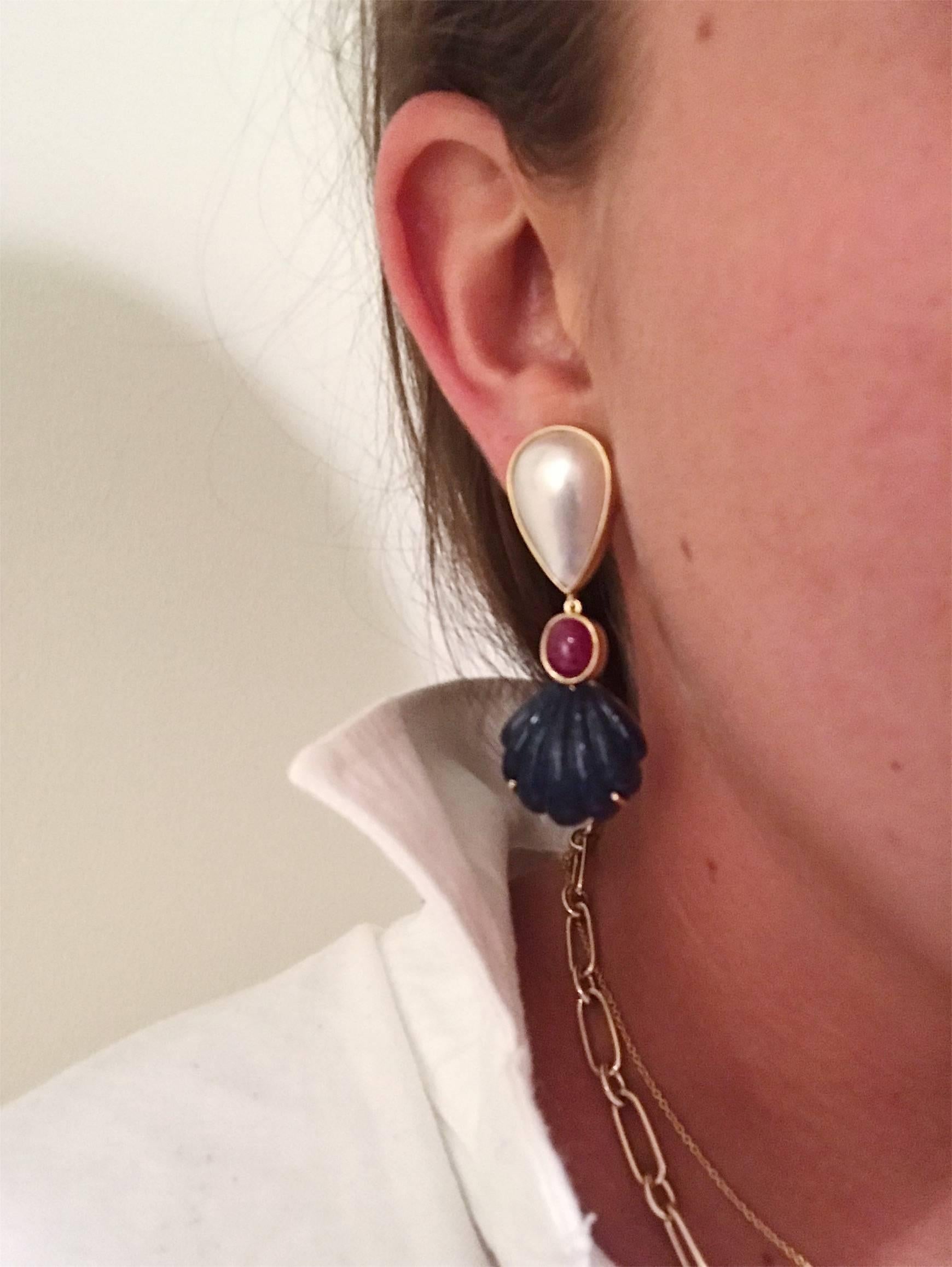 This elegant earring is 18kt Yellow Gold with  Mave Pearl and Rubellite and Carved Sea Shell Lapis. This is a stamped estate piece by Andrew Clunn. 

These earrings are clip-on, but posts can be added.

Please let me know if you have any