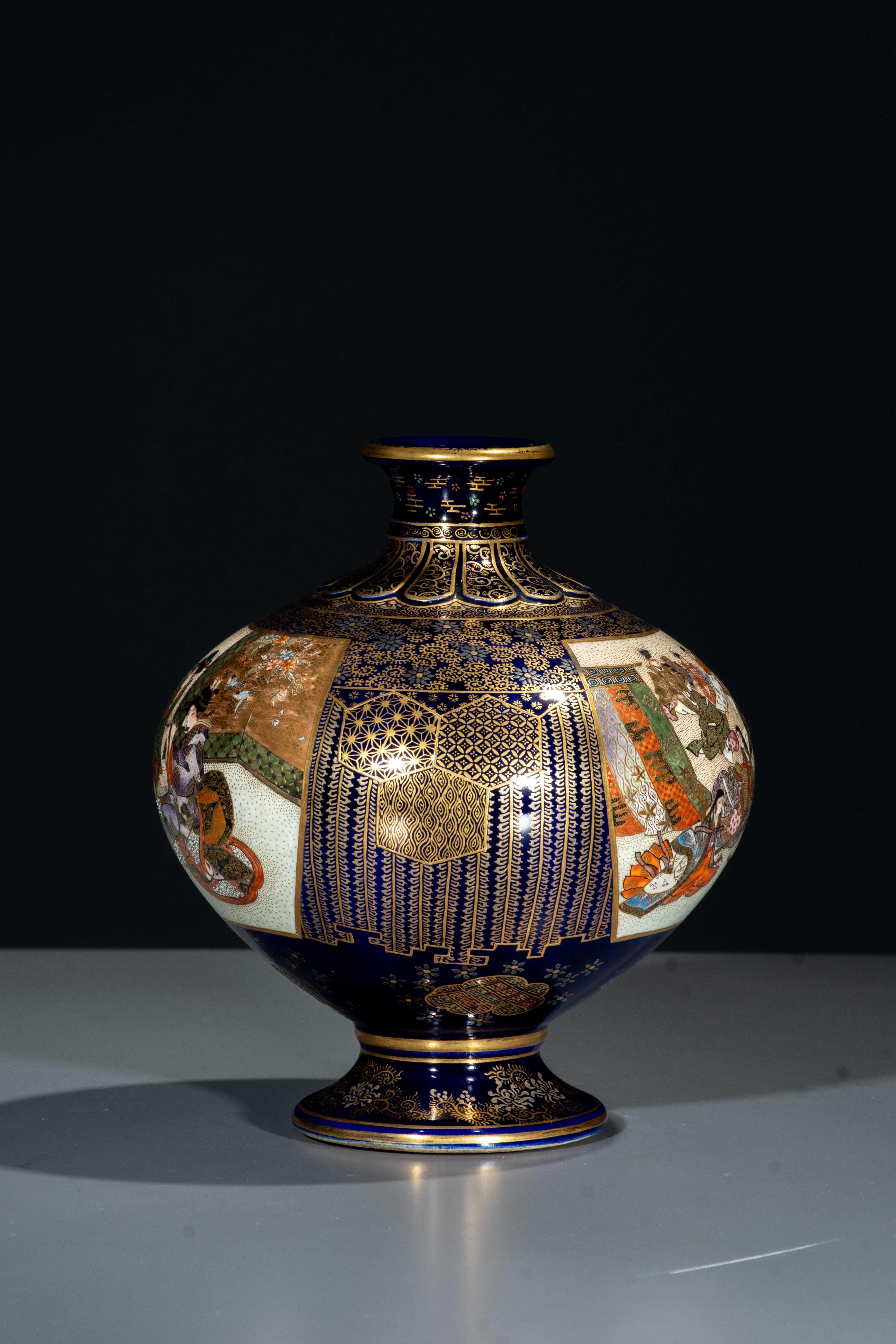 A globular Satsuma vase decorated with polychrome enamels and gold on a cobalt-blue ground. The neck features an elegant raised floral motif reminiscent of a chrysanthemum.
The body is adorned with large panels on a stippled ground, finely painted