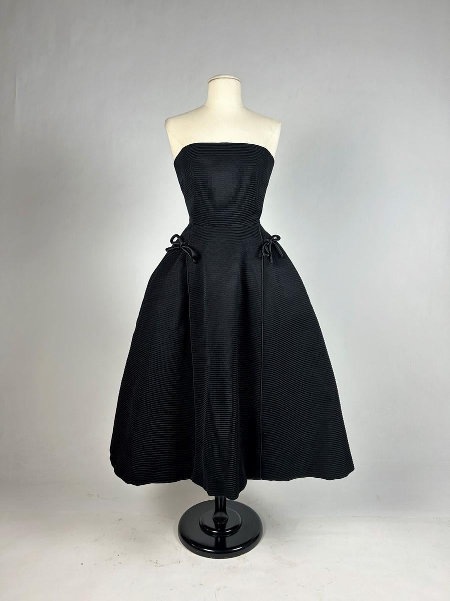 Autumn Winter 1952
Paris
Dress with large halter neckline in black silk ottoman, called Sonnet from the Profilée line - Christian Dior Haure Couture. Whalebone bustier with back zip, fully lined in black taffeta. Hip-length skirt emphasised by black