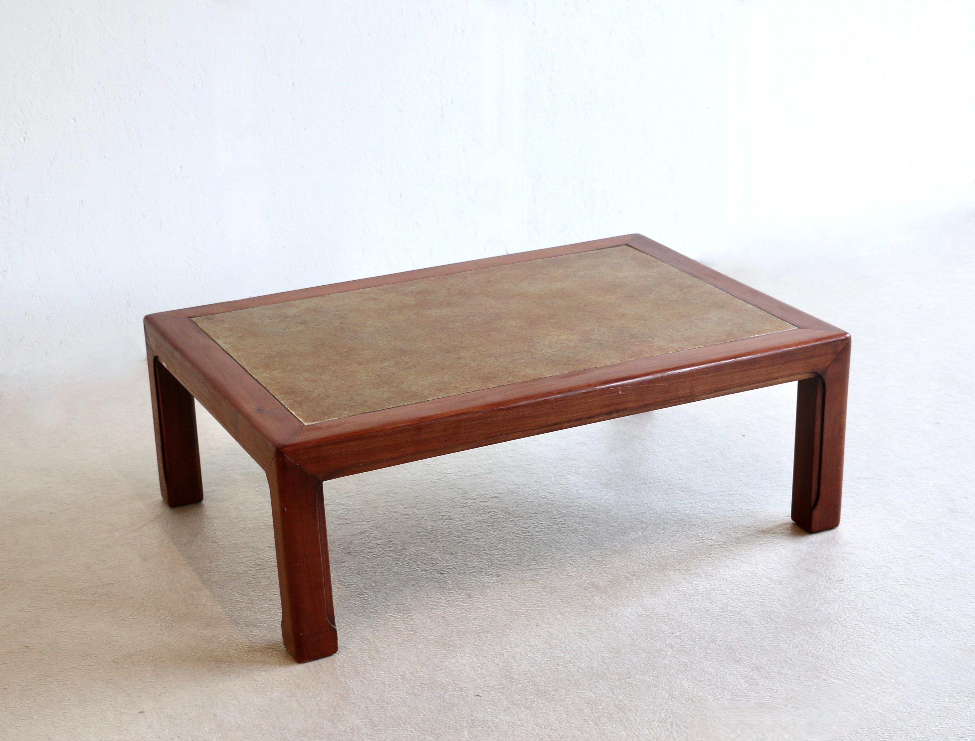 Dieser Couchtisch ist sehr originell, denn er hat eine Keramikplatte, die wie Leder aussieht, und einen massiven Mahagonisockel.