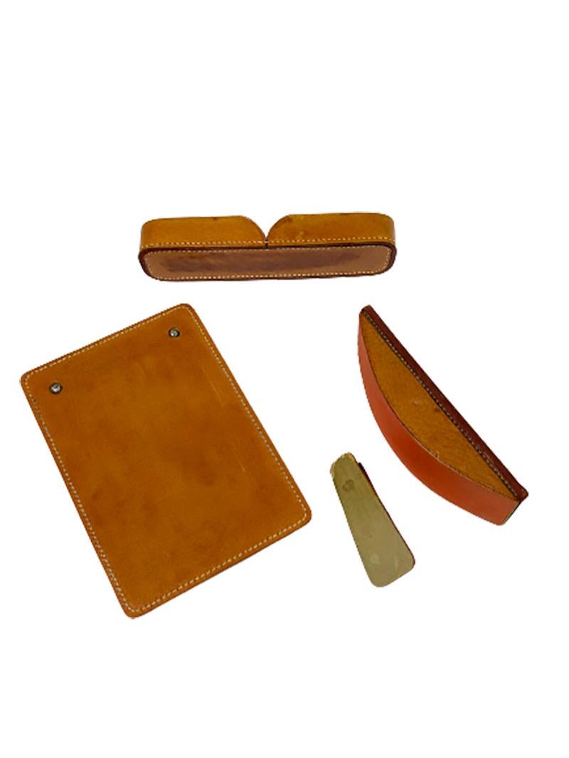 A cognac colored stitched leather desk set.

Consisting of 4 pieces, which are used items with signs of wear. The clip (paper clamp) made of brass. The Notepad, the writing paper block is clamped between the chrome colored screw screws and