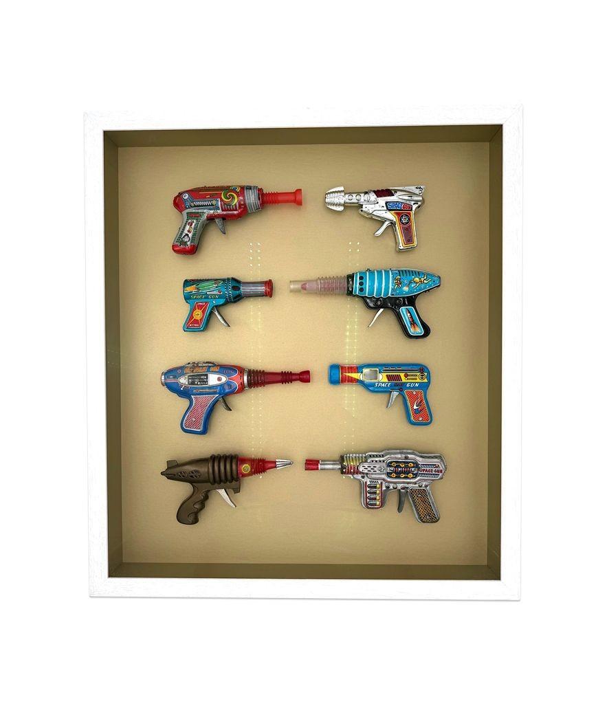 A collection of 1960s/70s tinplate and plastic ray guns mounted in a box frame. In Good Condition For Sale In London, GB