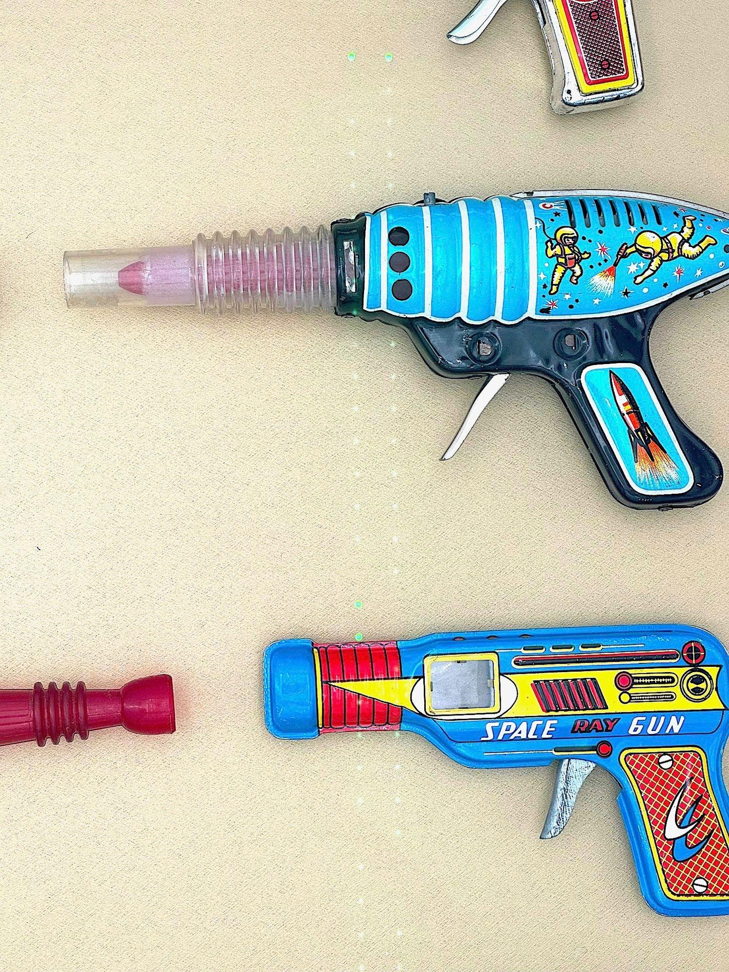 A collection of 1960s/70s tinplate and plastic ray guns mounted in a box frame. For Sale 2