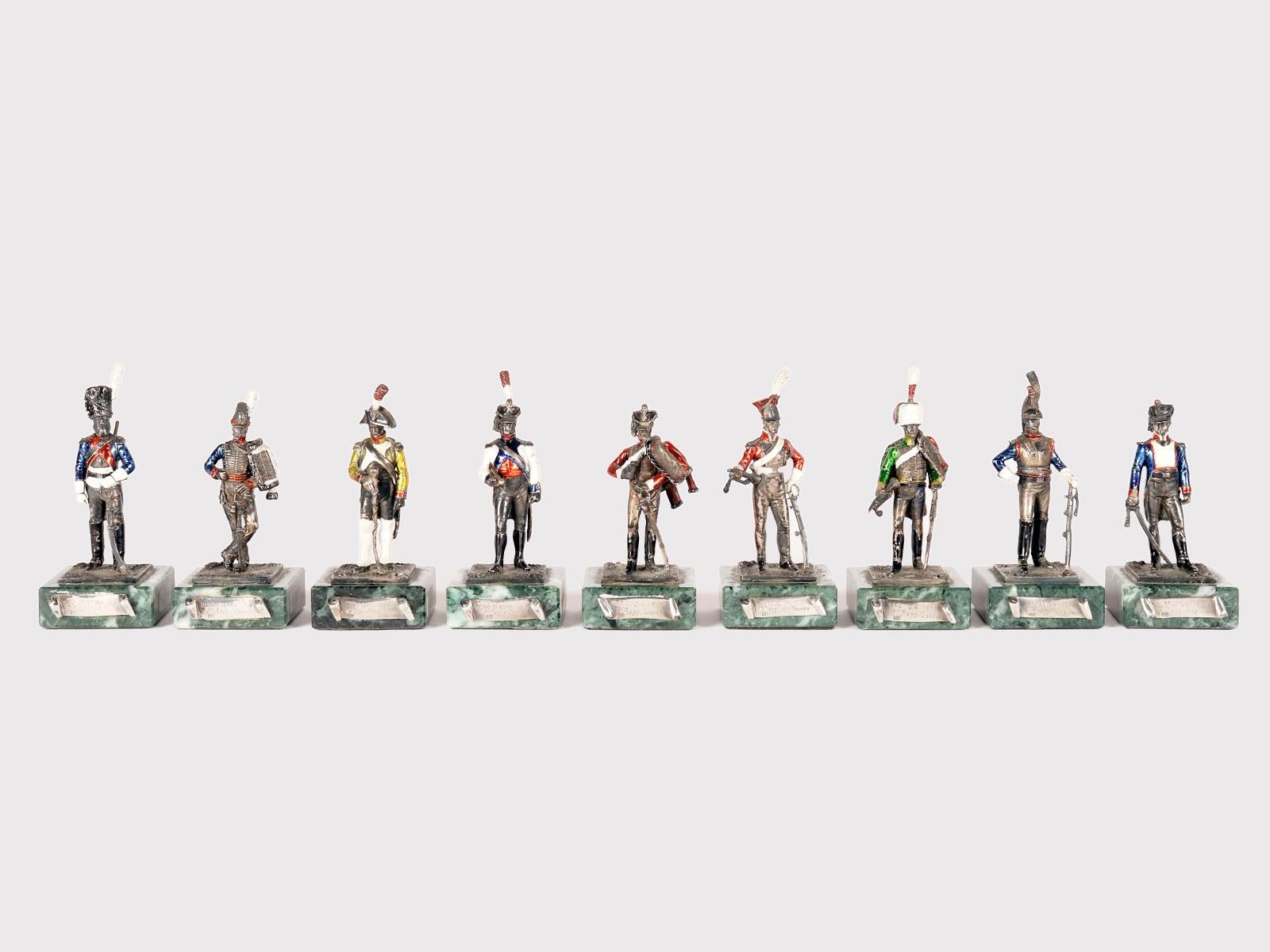 Il gruppo di 9 sculture è realizzato in argento 800/1000, smalto e una base di marmo verde delle Alpi. La base è quadrata, si alza perpendicolarmente e ha gli angoli arrotondati. Sulla parte anteriore della base, un cartiglio descrive l'origine e il