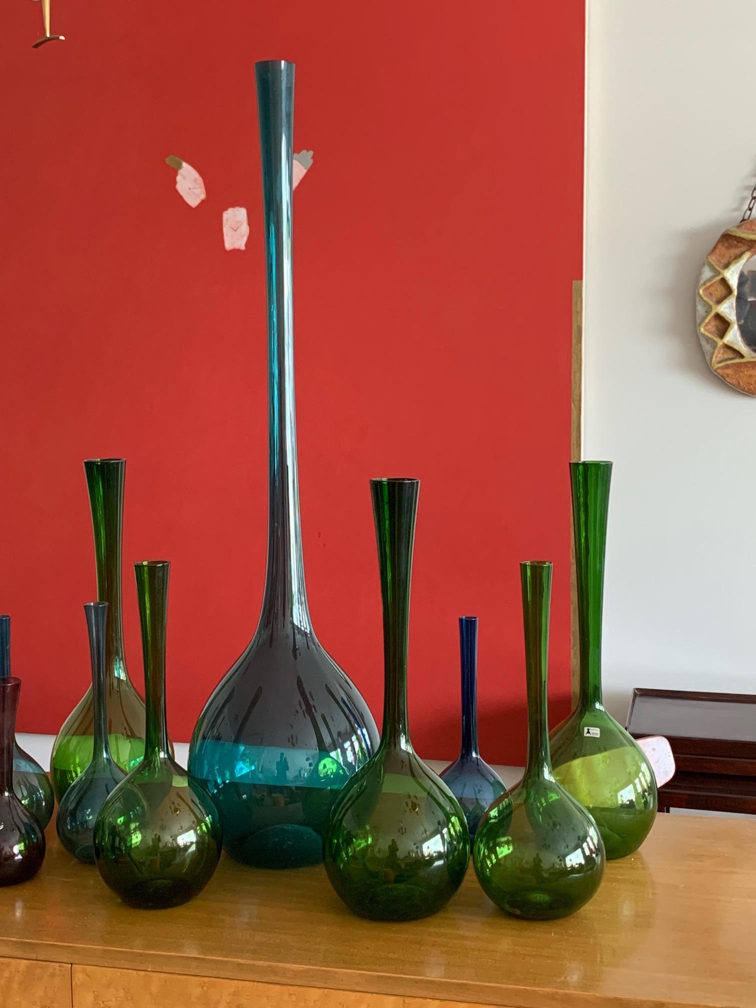 A collection of sixteen glass pieces by Seda (Sweden), circa 1960s-1970s. Bottle shapes in green, blue, amber, largest measuring 39