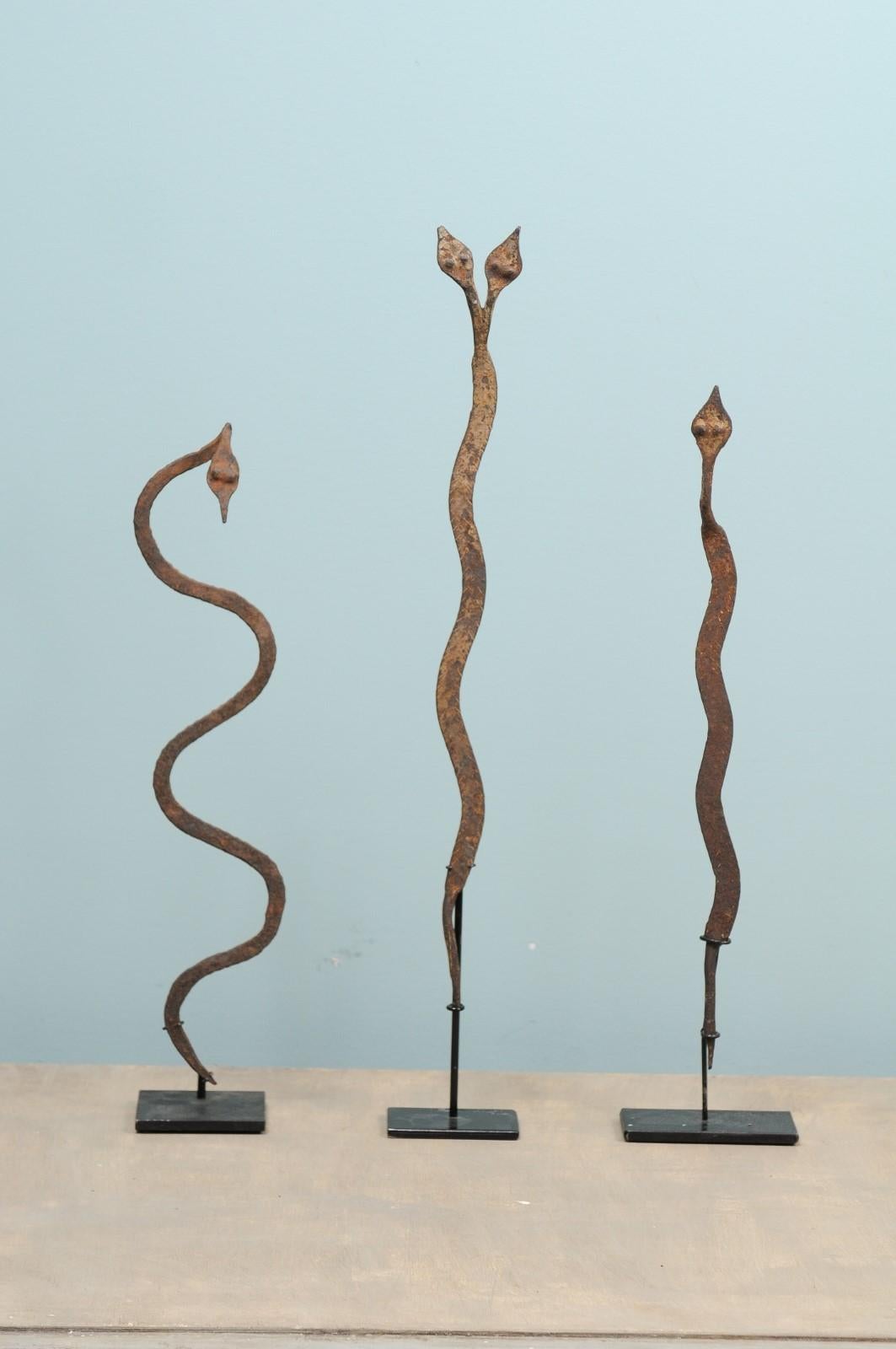 A collection of Burkina Faso currency from the mid-20th century. This assortment of three vintage African ritual iron snakes effigies originate from the Lobi tribe of Burkina Faso. These serpent shaped currencies are made of iron, have a lovely