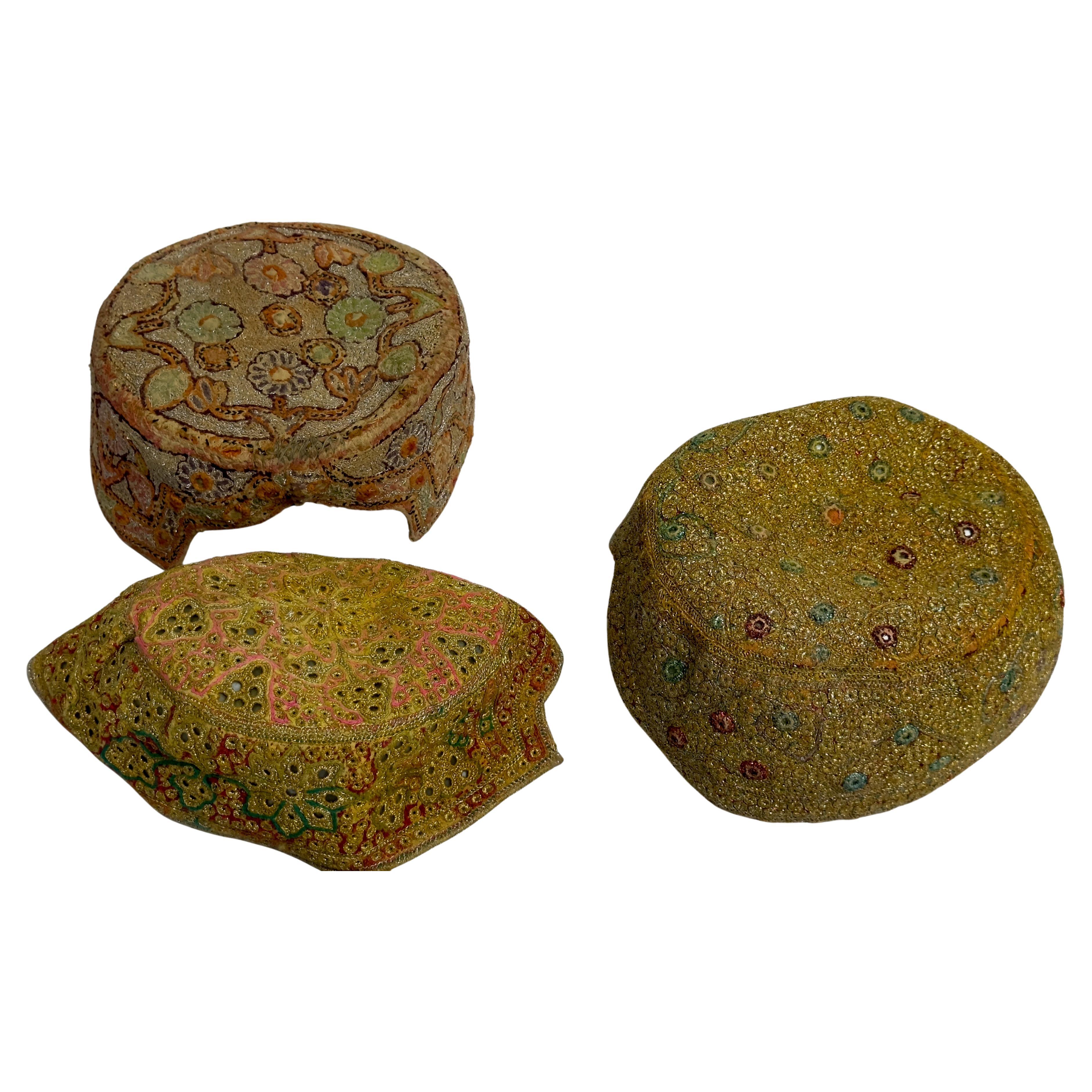 Una colección de tres sombreros afganos bordados en venta
